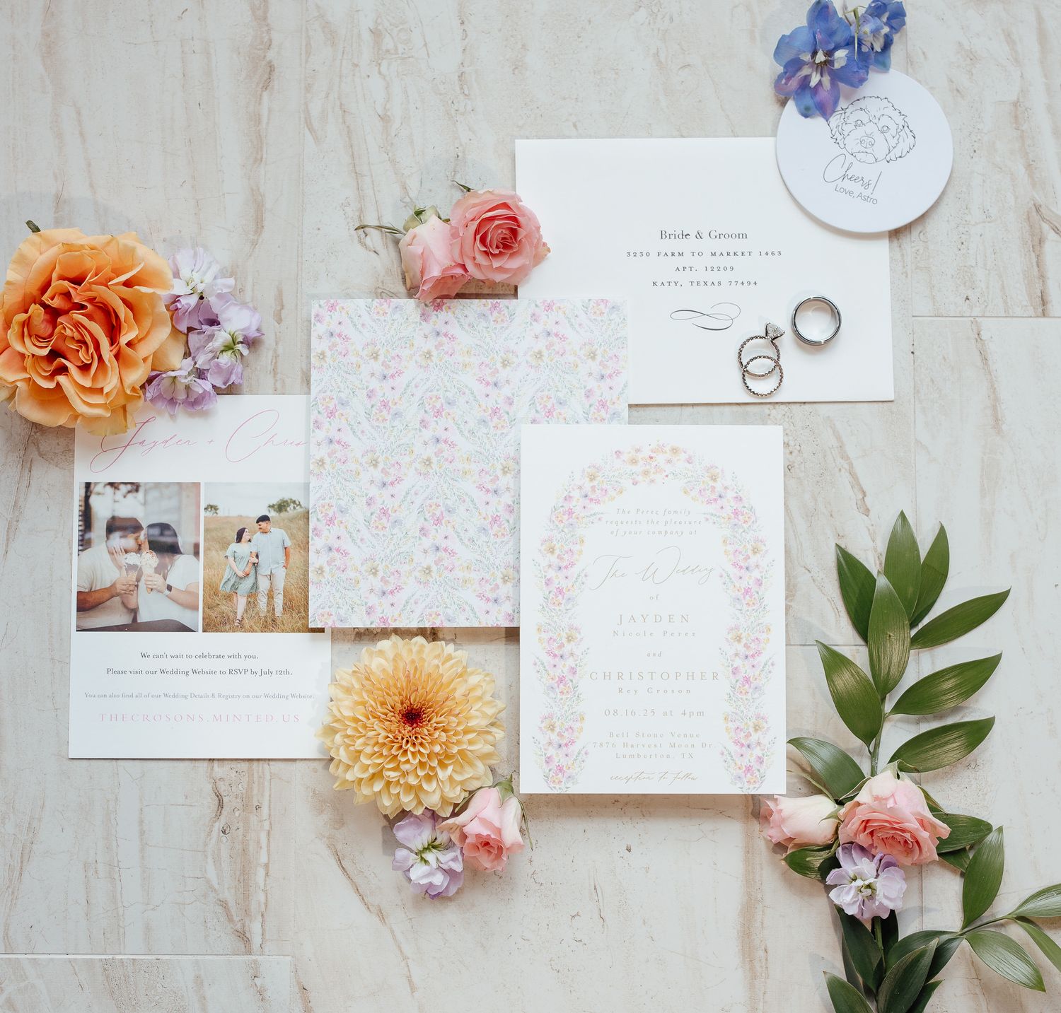 Wedding stationery flat lay with floral design, photos and fresh flowers on marble background.