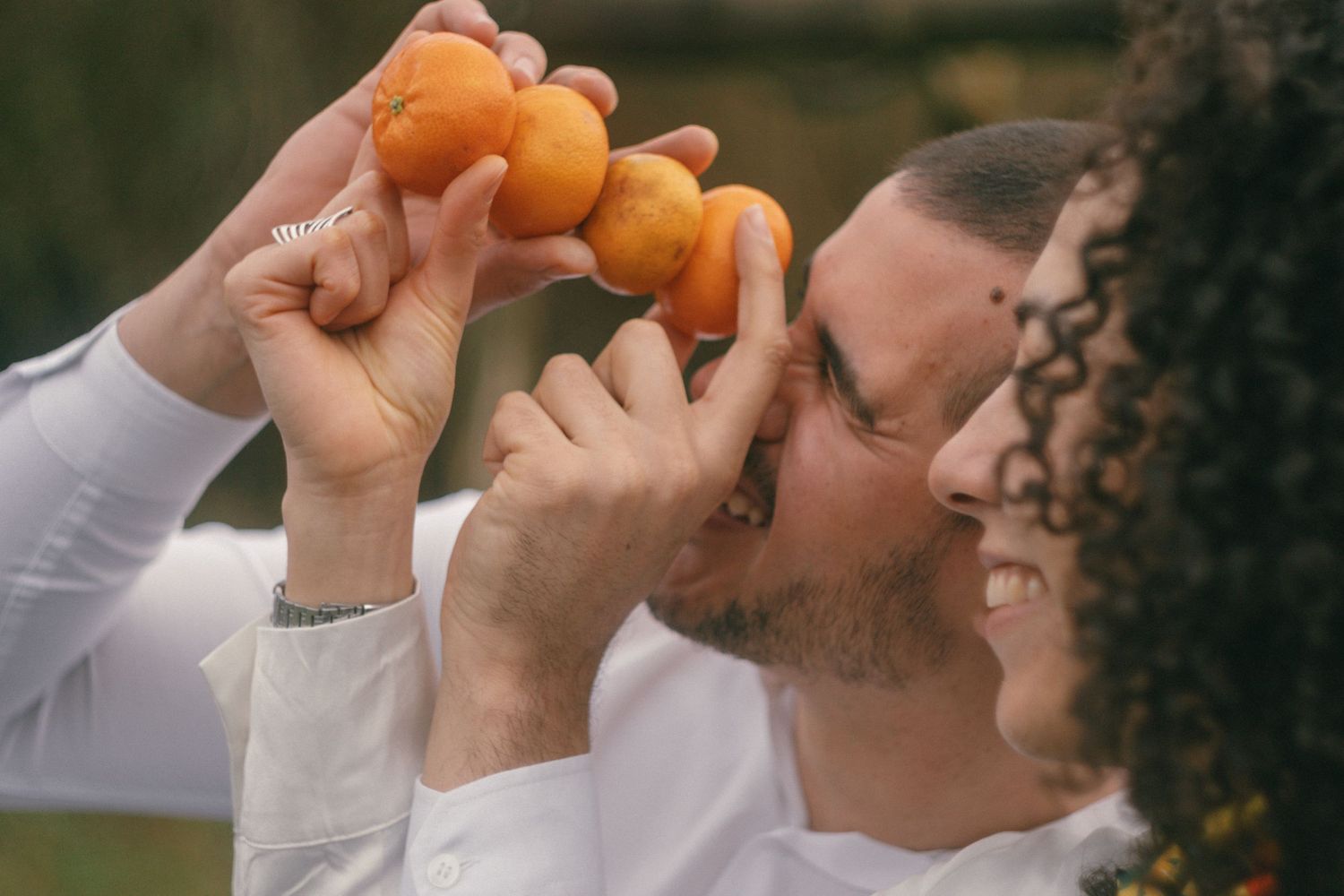 Casual and cinematic photoshoot of couple playing around with tangerines