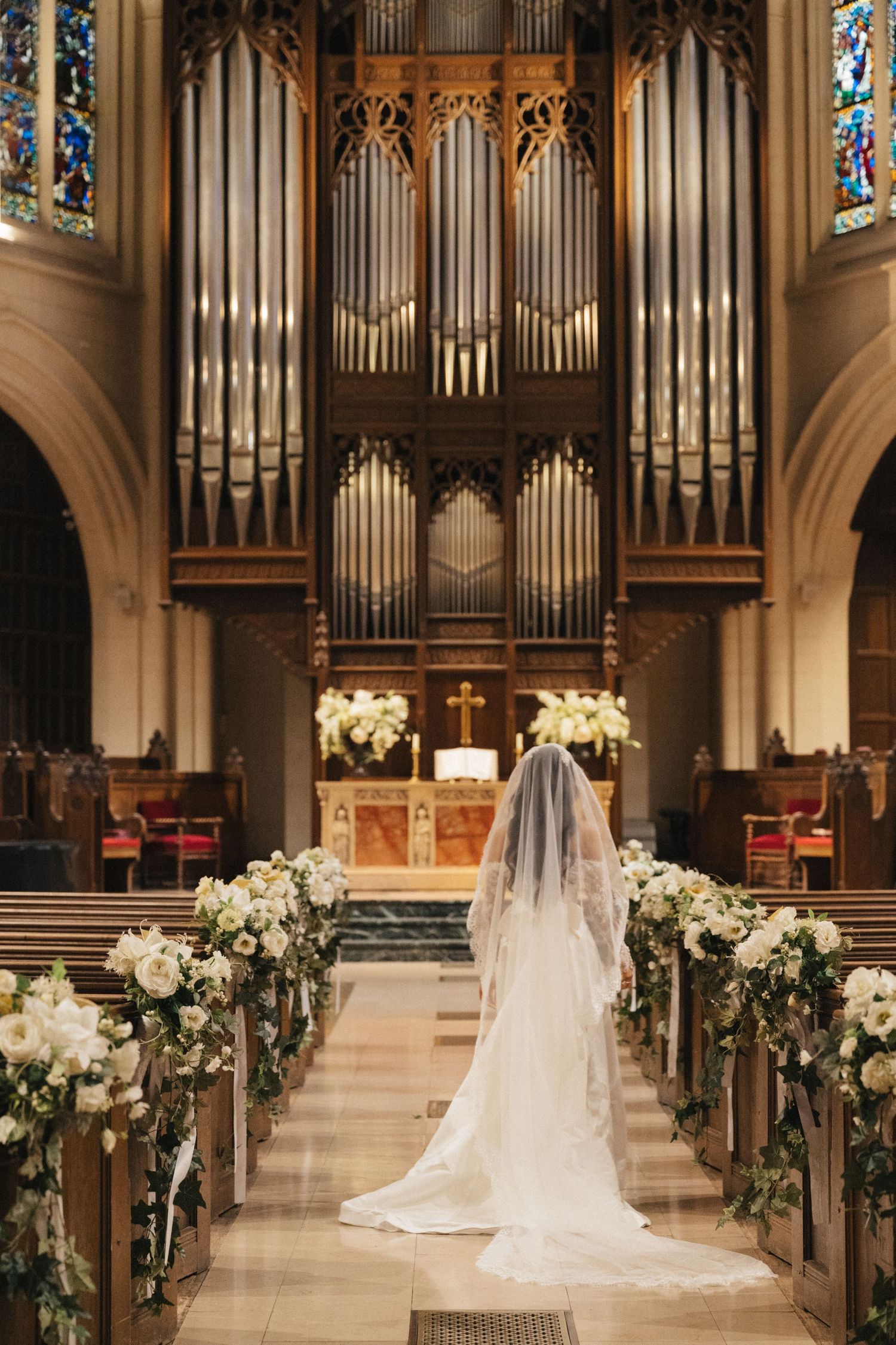 American church in paris wedding, the bride walking down the aisle, her veil is long