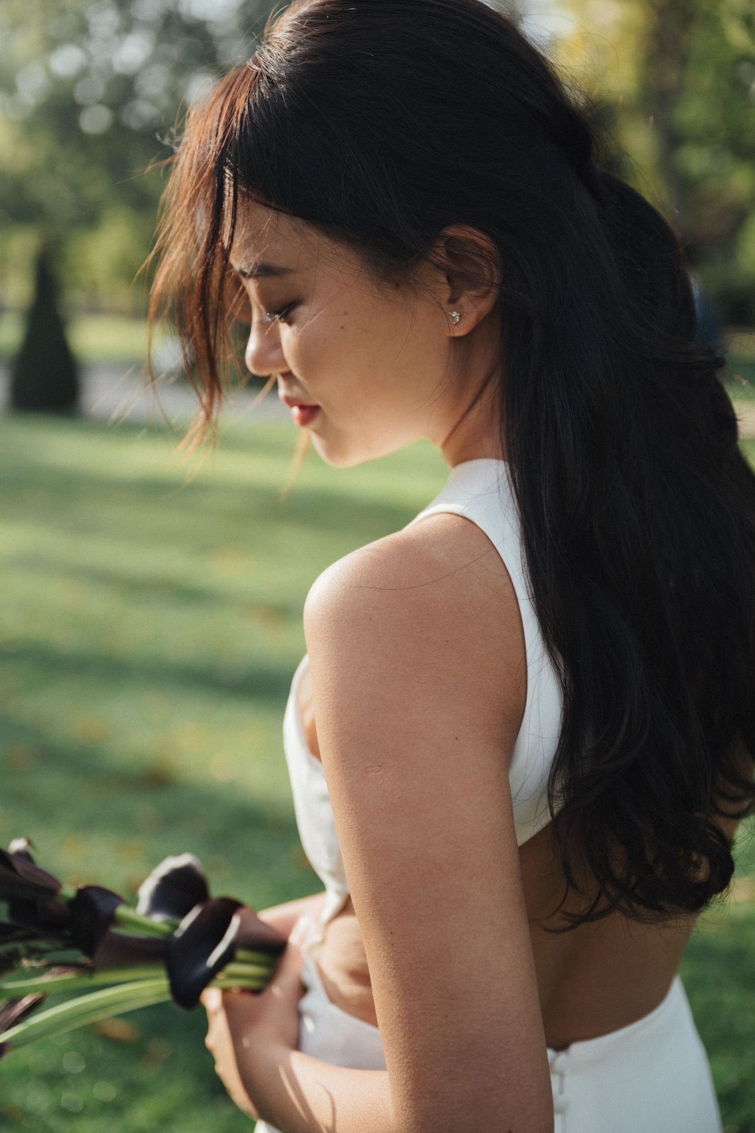 Bridal portrait at Parc de la Planchette, bride holding Purple calla lily while looking down
