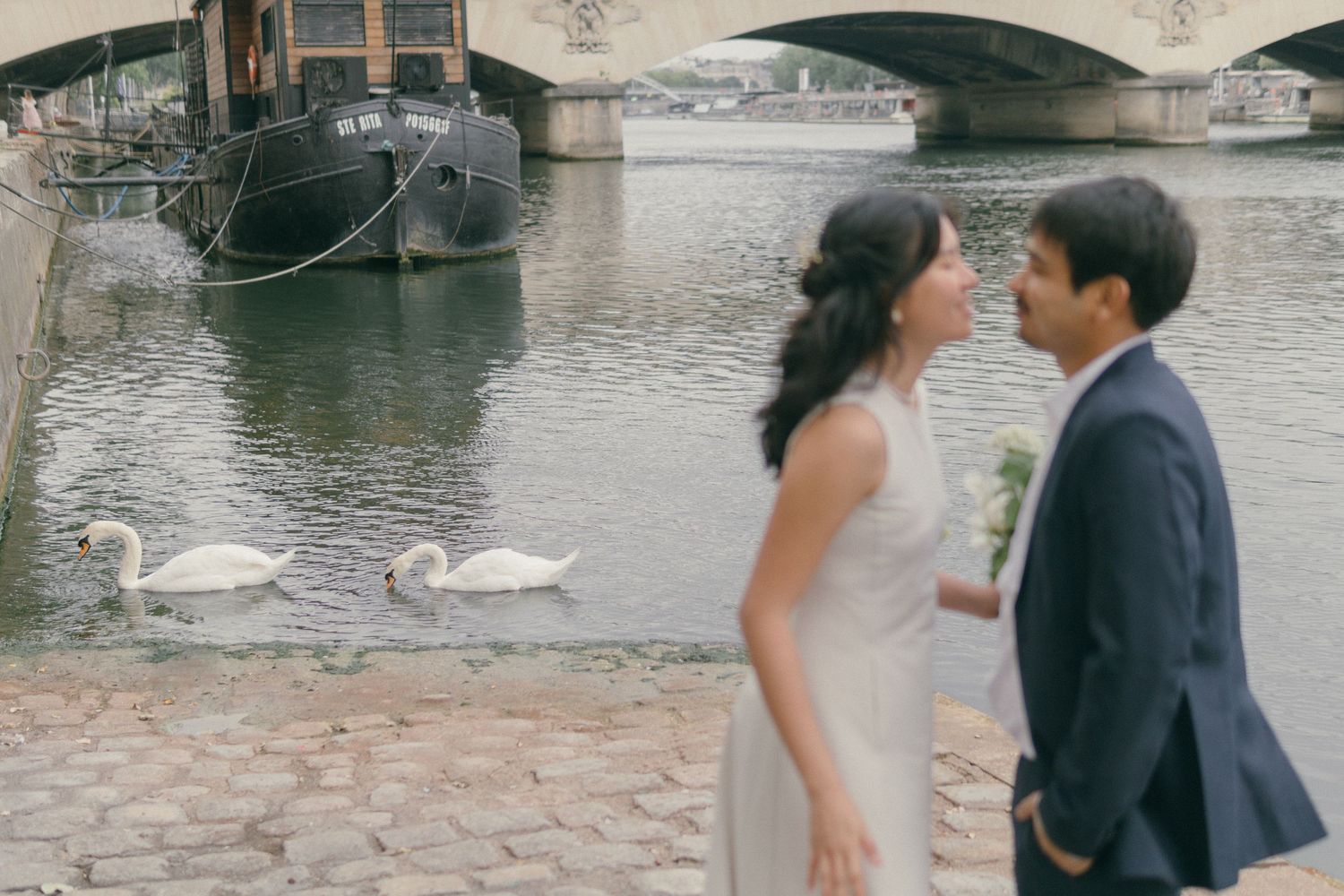 Seine river couple romantic photoshoot, with swans behind them
