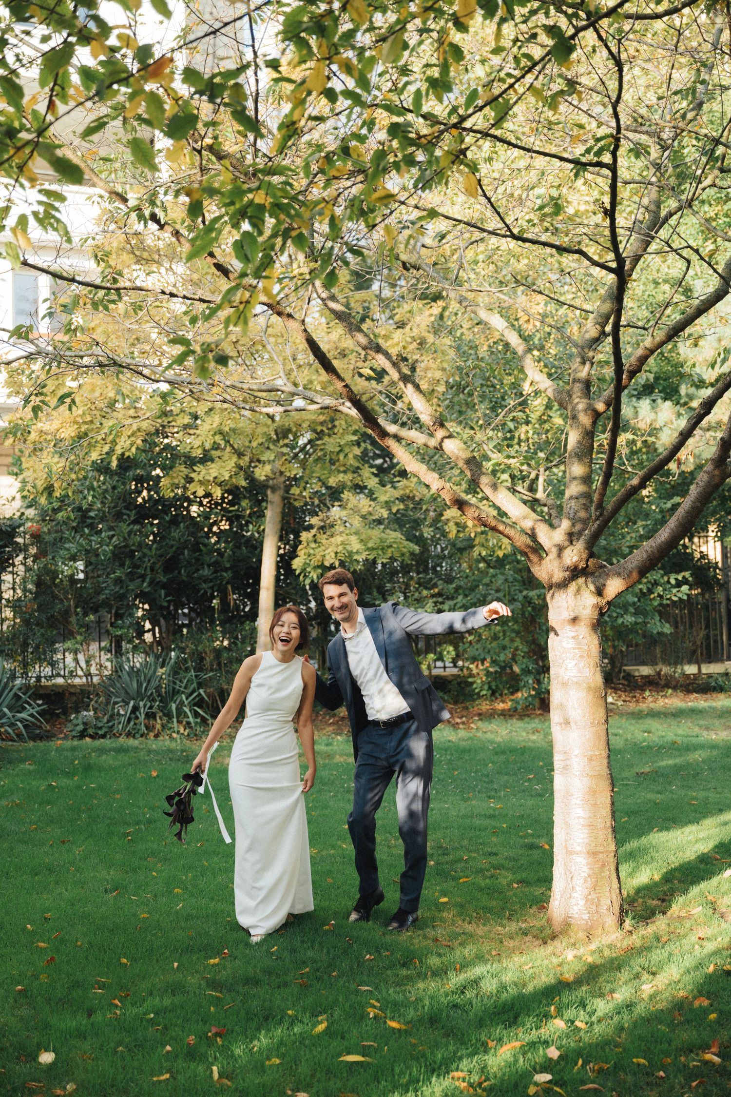 Wedding couple portrait at parc de la planchette, groom and bride laughing at the camera