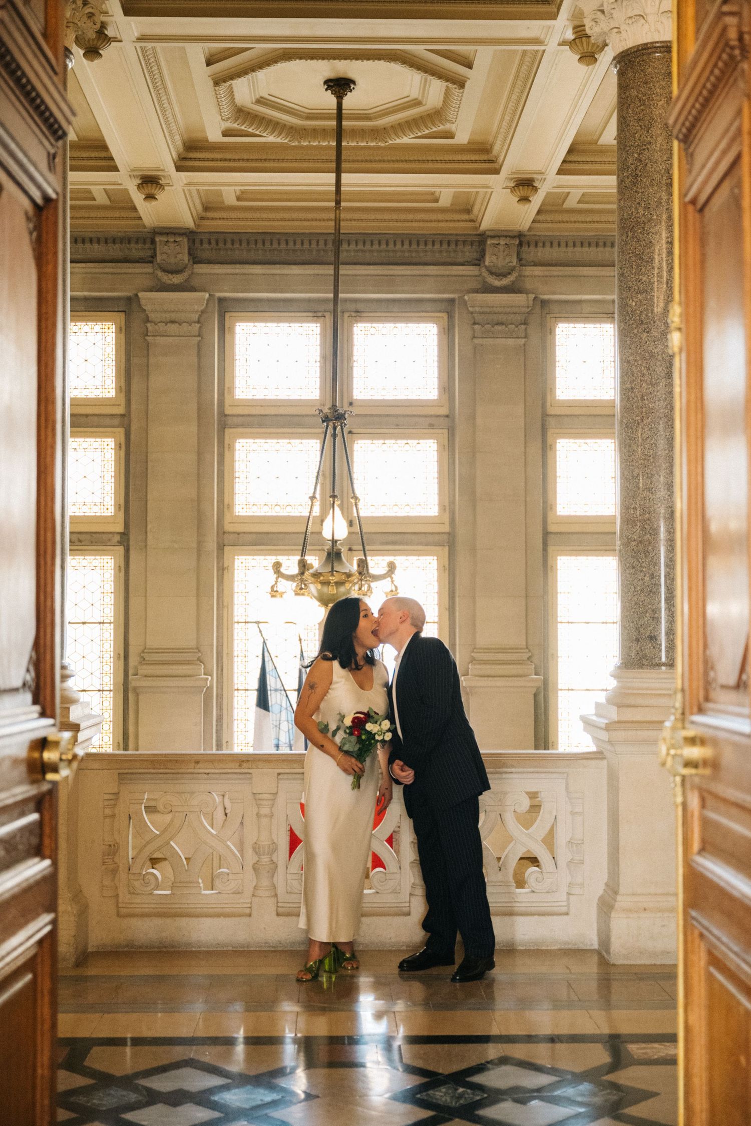 Civil wedding ceremony at mairie 14ème, bride and groom kiss outside of the ceremony room