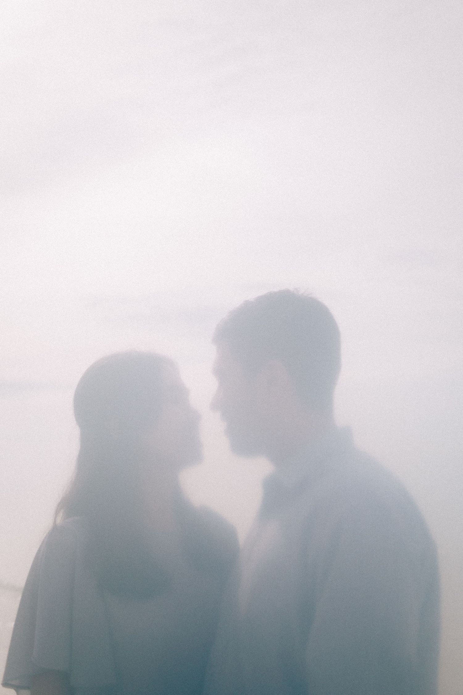 Pre-wedding photo of couple looking at each other dreamy and hazy