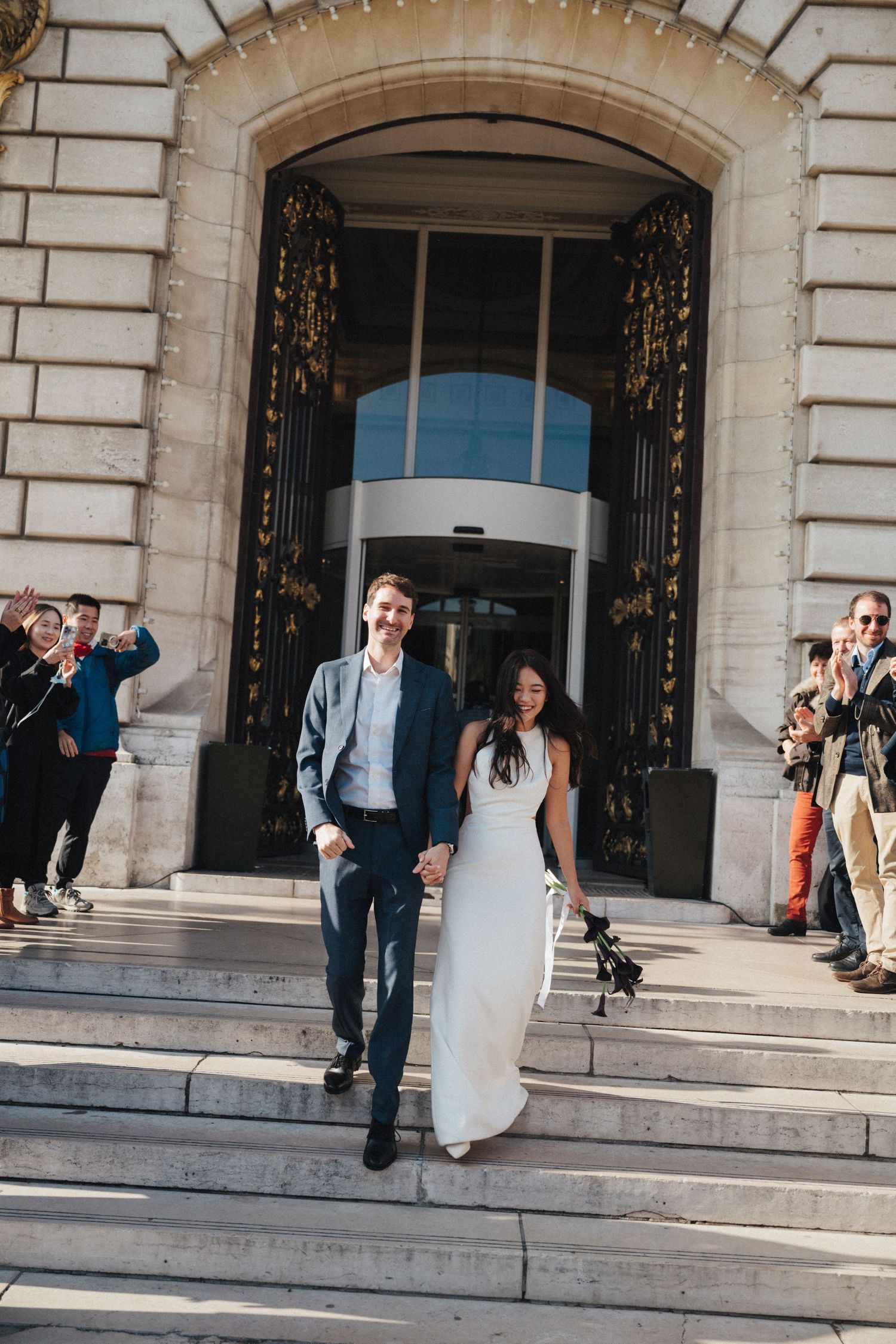Civil wedding at Mairie de Levallois-Perret, groom and bride exit the building of hotel de ville while their friends cheered on them