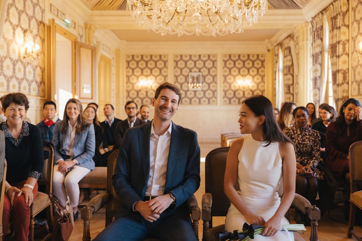 Civil wedding ceremony at Mairie de Levallois-Perret, bride looking at the groom while the groom smile at the camera