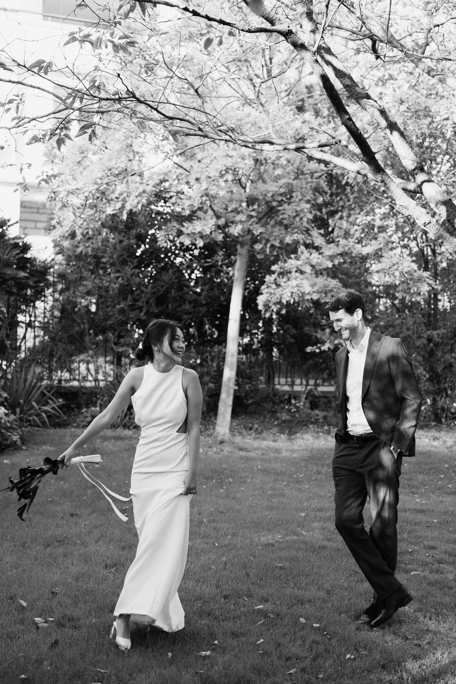 Wedding couple portrait at Parc de la Planchette, groom and bride laughing, black and white photo