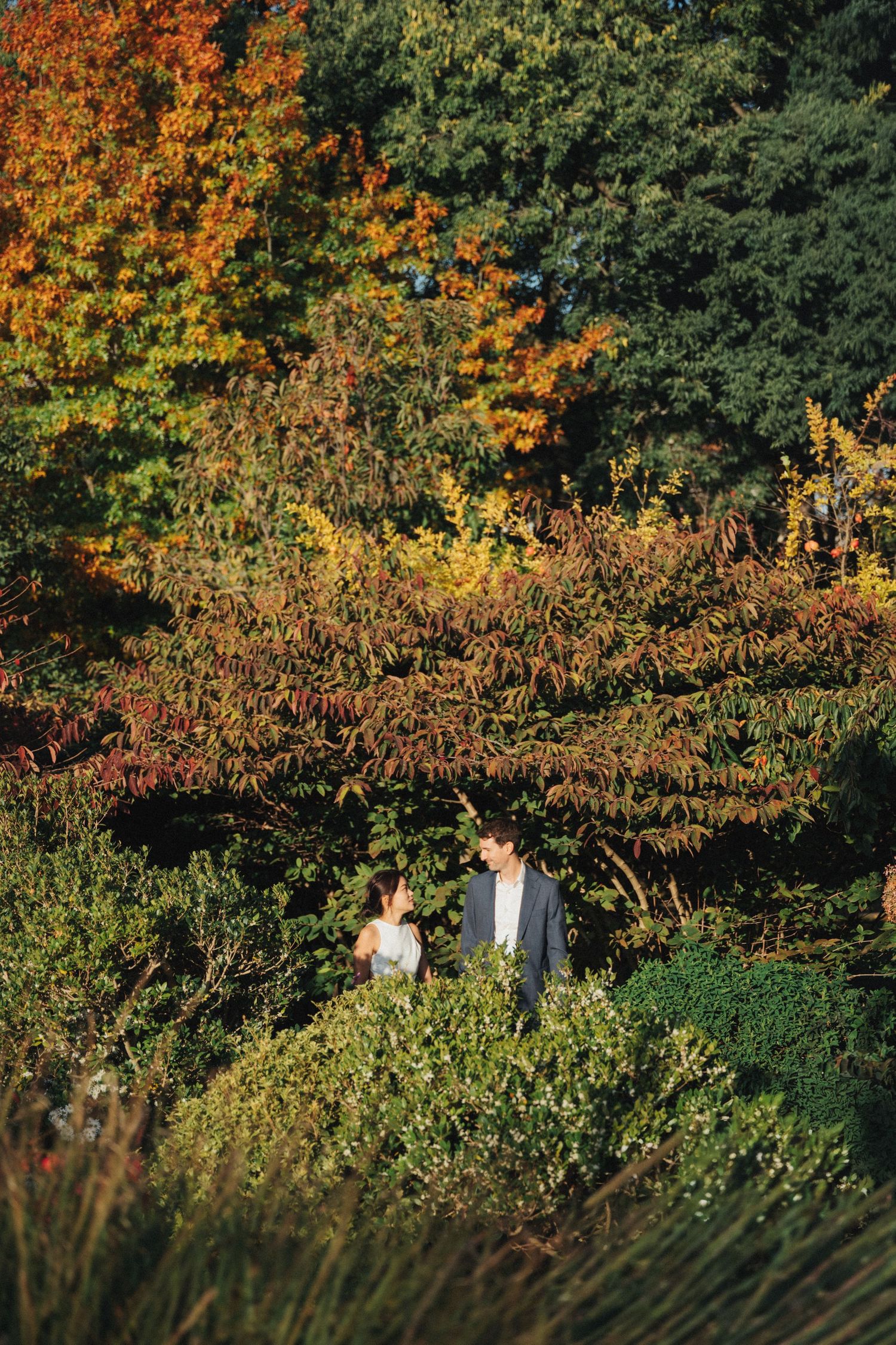 Wedding couple portrait at parc de la planchette, groom and bride looking at each other, autumn colors