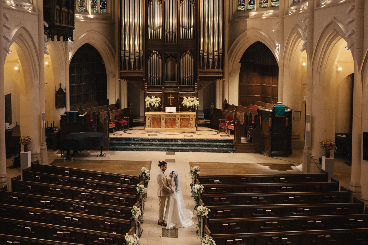american church in paris wedding after ceremony, the bride and groom standing alone in the church's interior