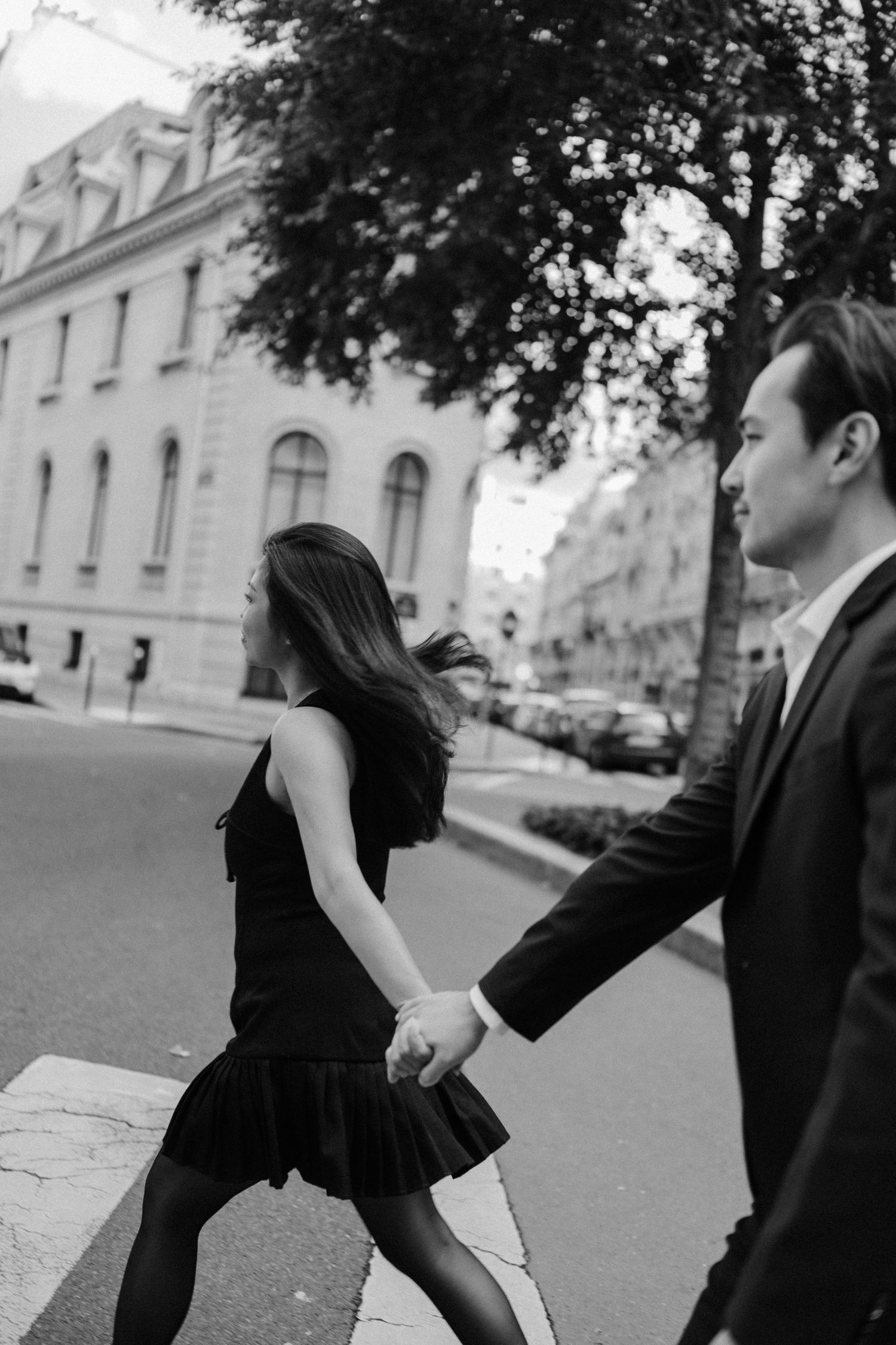 Engagement photoshoot at avenue rapp, couple wearing black walking down the street