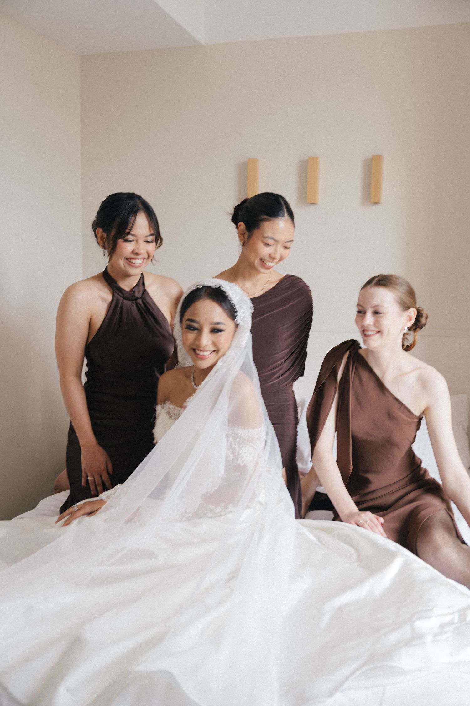 Bride and bridesmaids photoshoot at a hotel room, laughing at each other