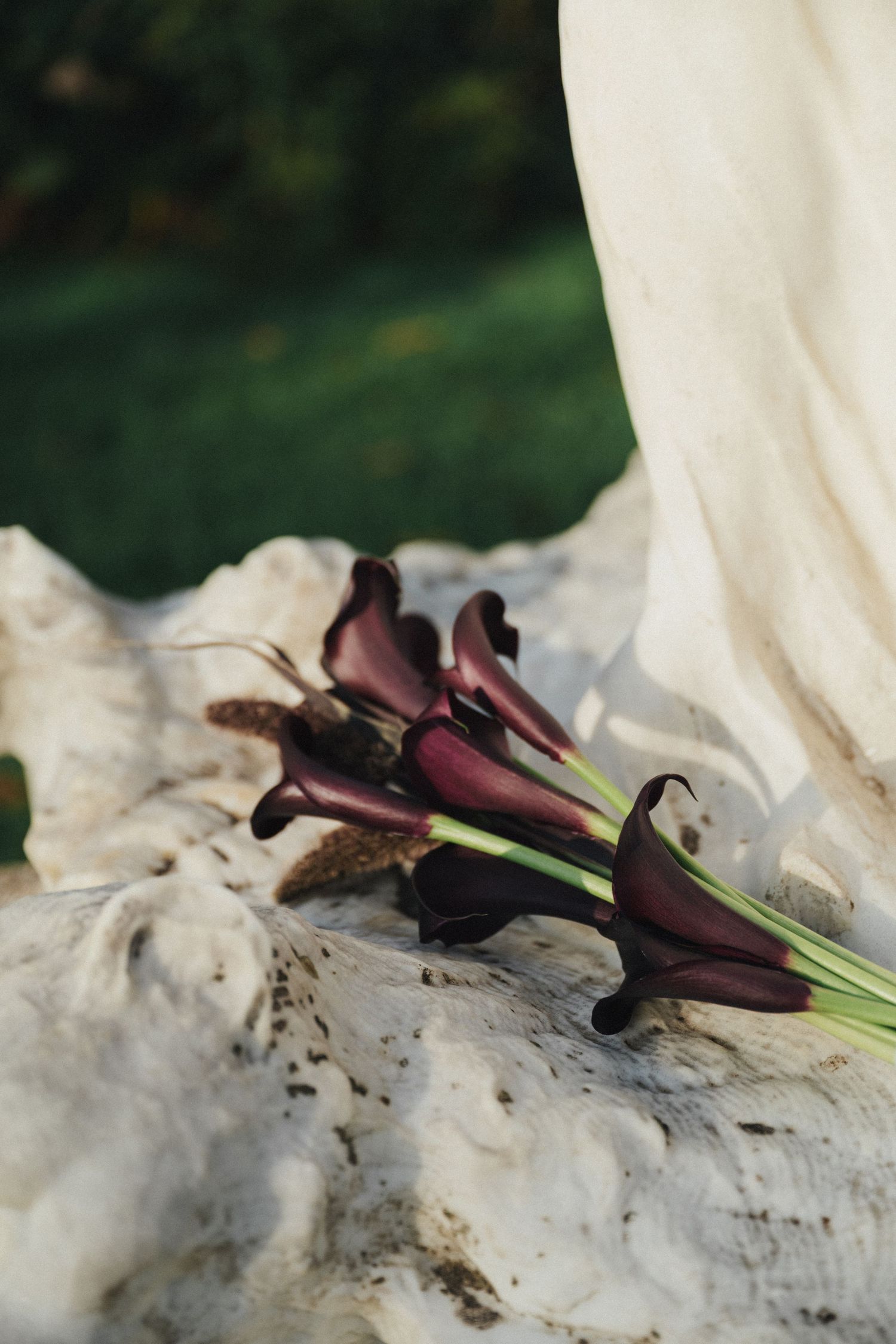 Purple calla lily wedding bouquet on a statue at Parc de la planchette