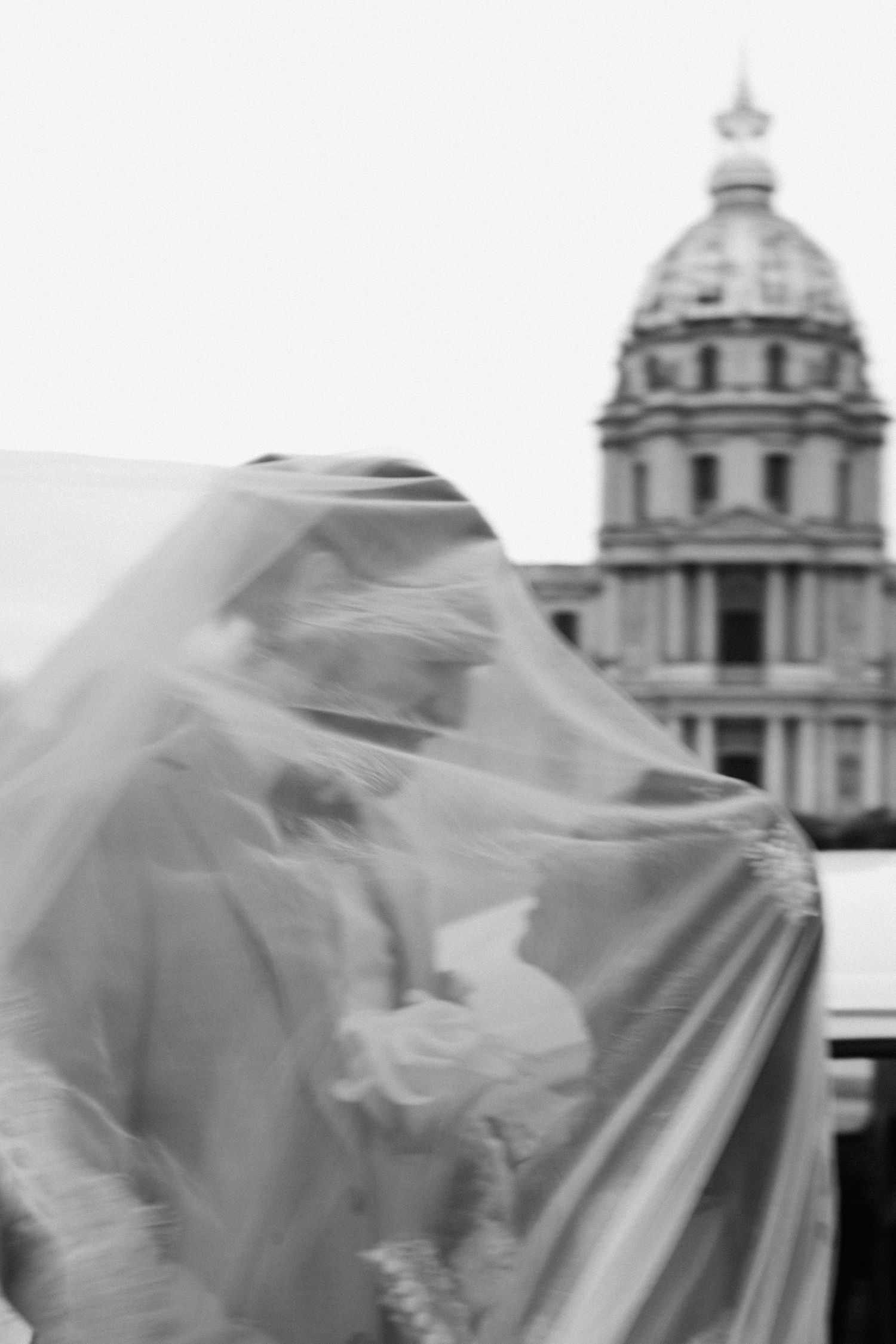 Black and white wedding couple portrait with invalides paris behind them
