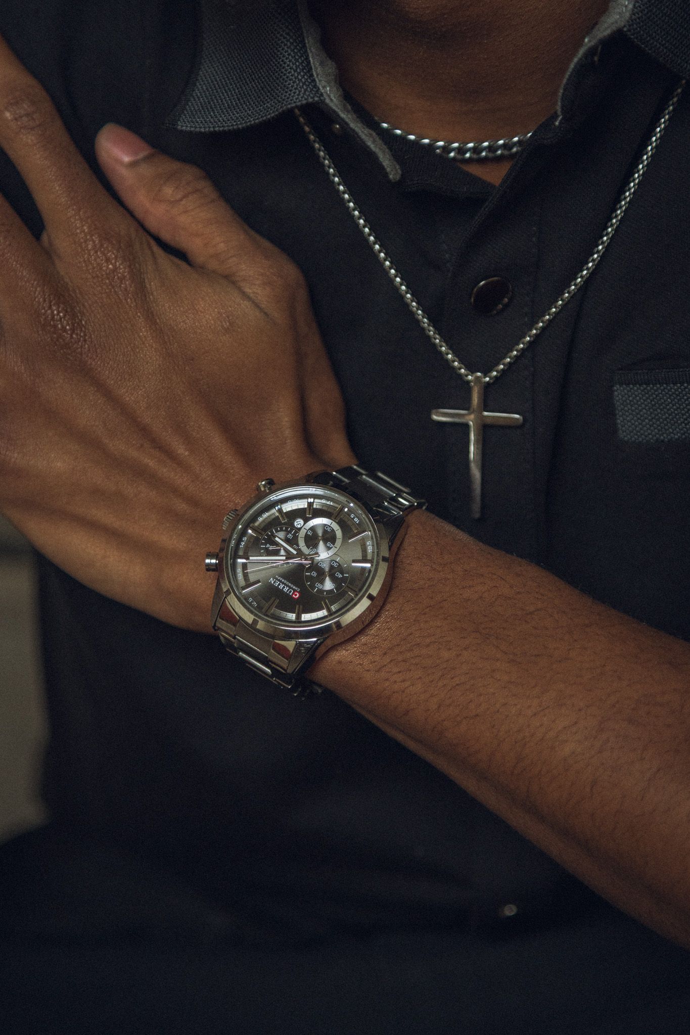 Close-up series showing hands displaying and adjusting a stylish silver watch with chain necklace accessories.