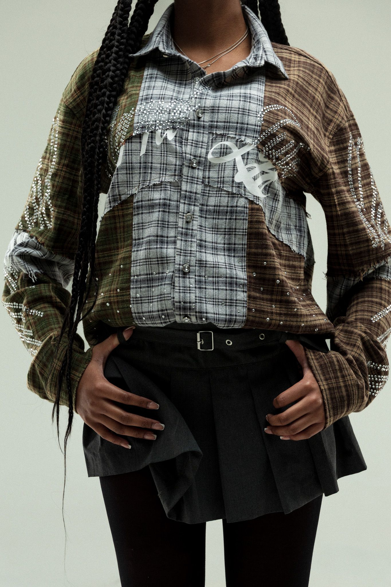 A plaid shirt and black skirt outfit shown from different angles against a white background.