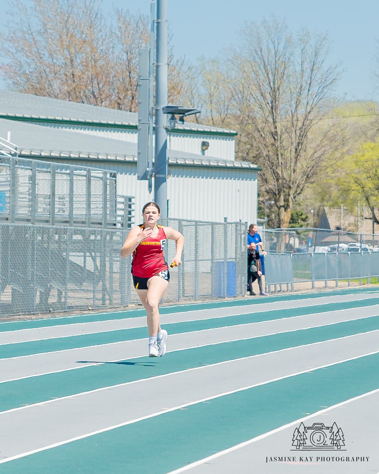 A sequence showing disc throwing technique demonstrated on a green track with buildings in the background.