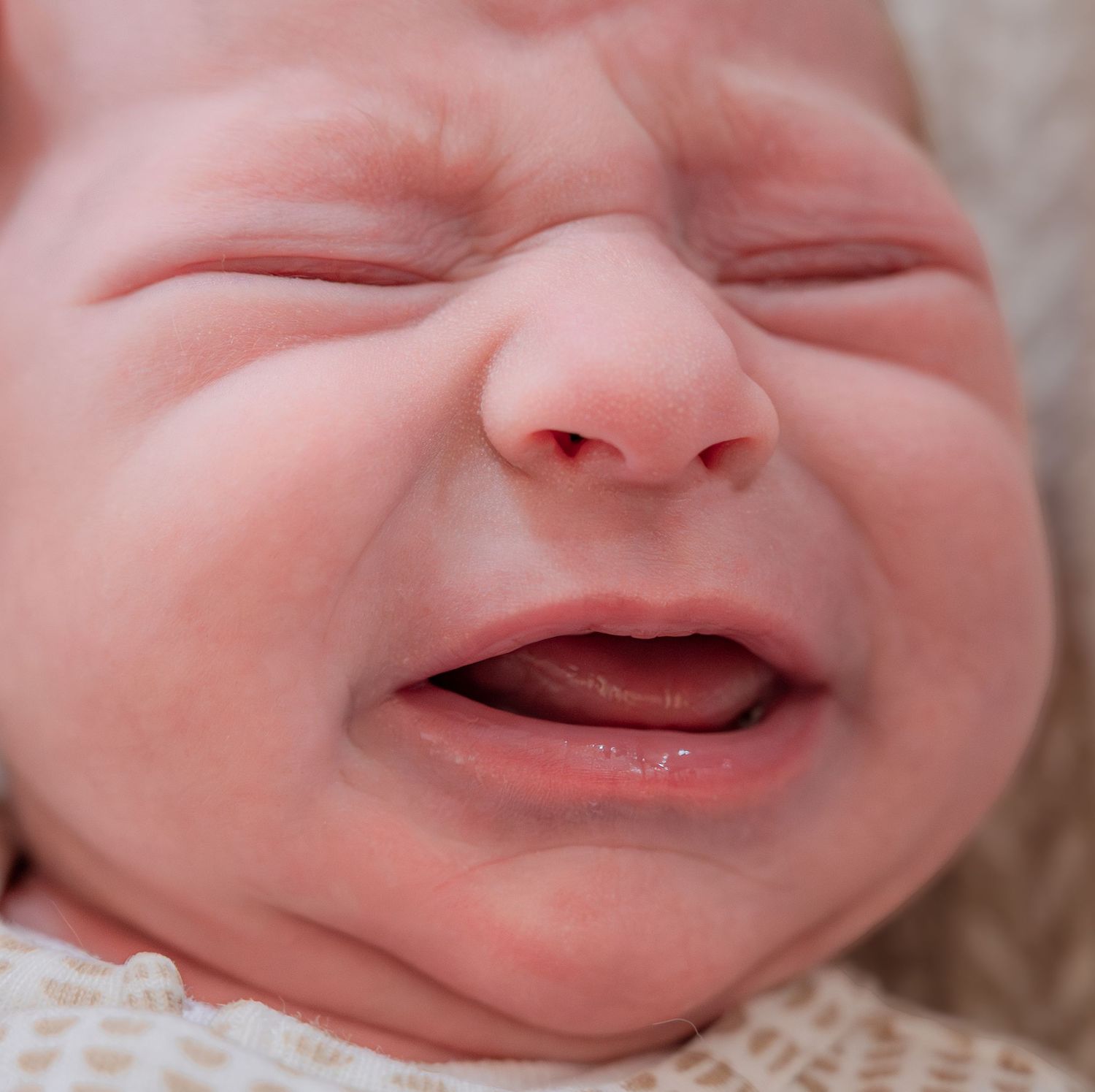 Close up of a newborn baby's face showing different expressions and smiles in a series of photos.