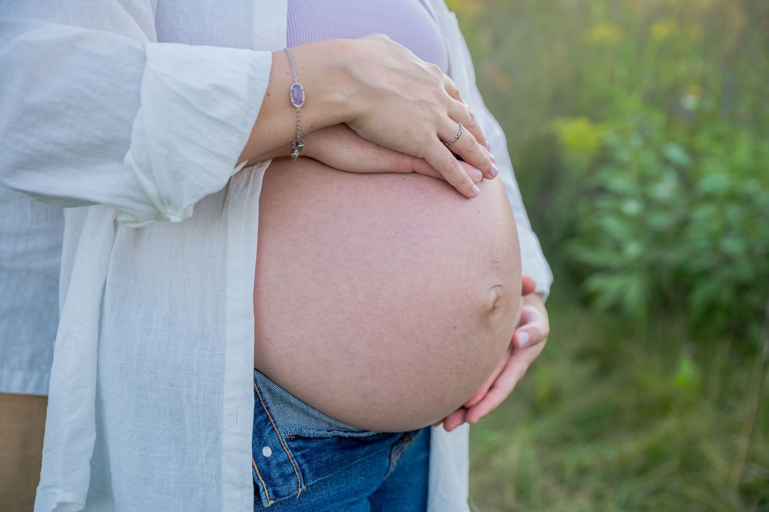A series of pregnancy progression photos showing a growing baby bump against a natural outdoor background.