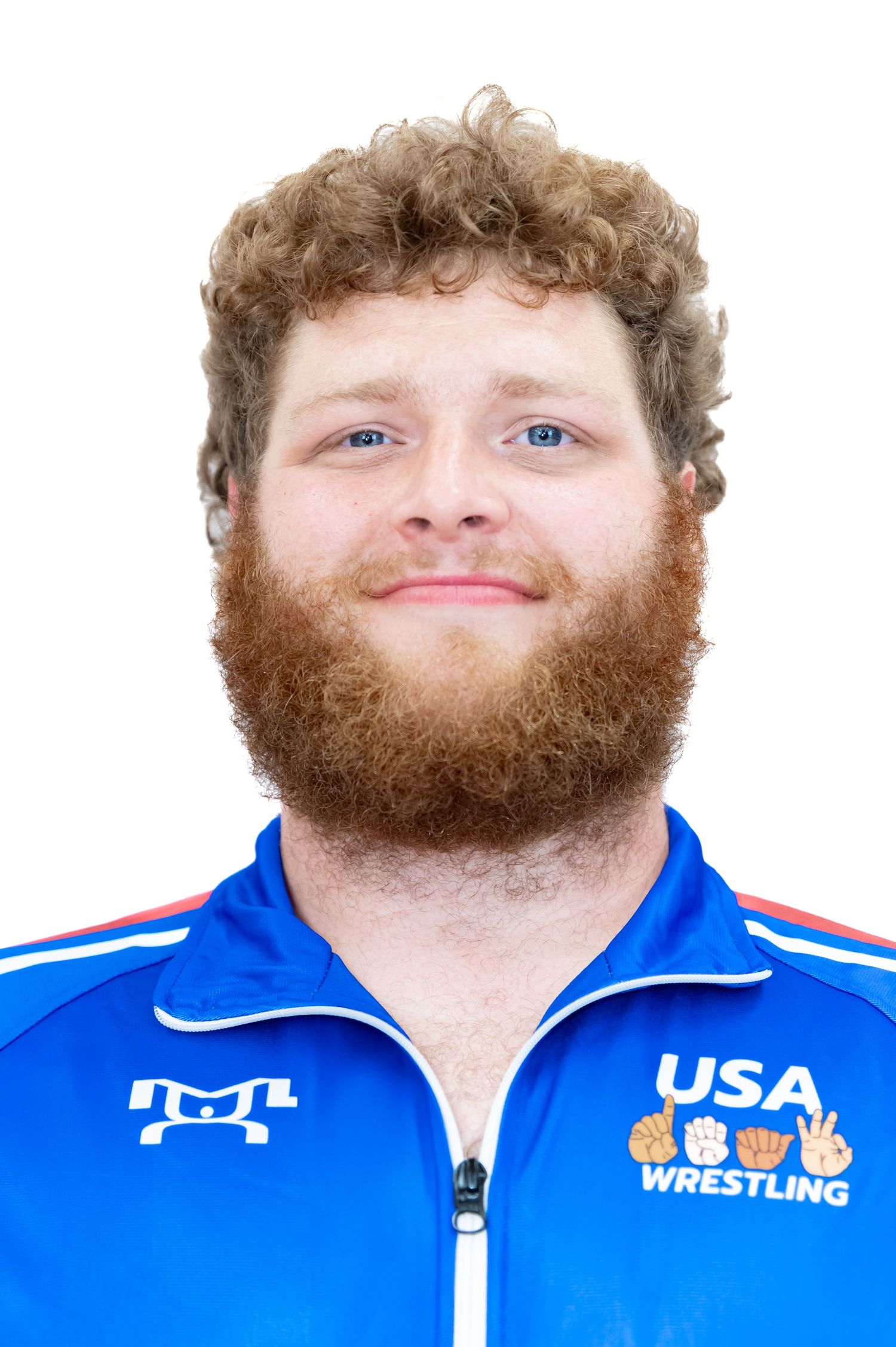 Person in blue USA Wrestling team jacket smiles at camera in headshot portrait.
