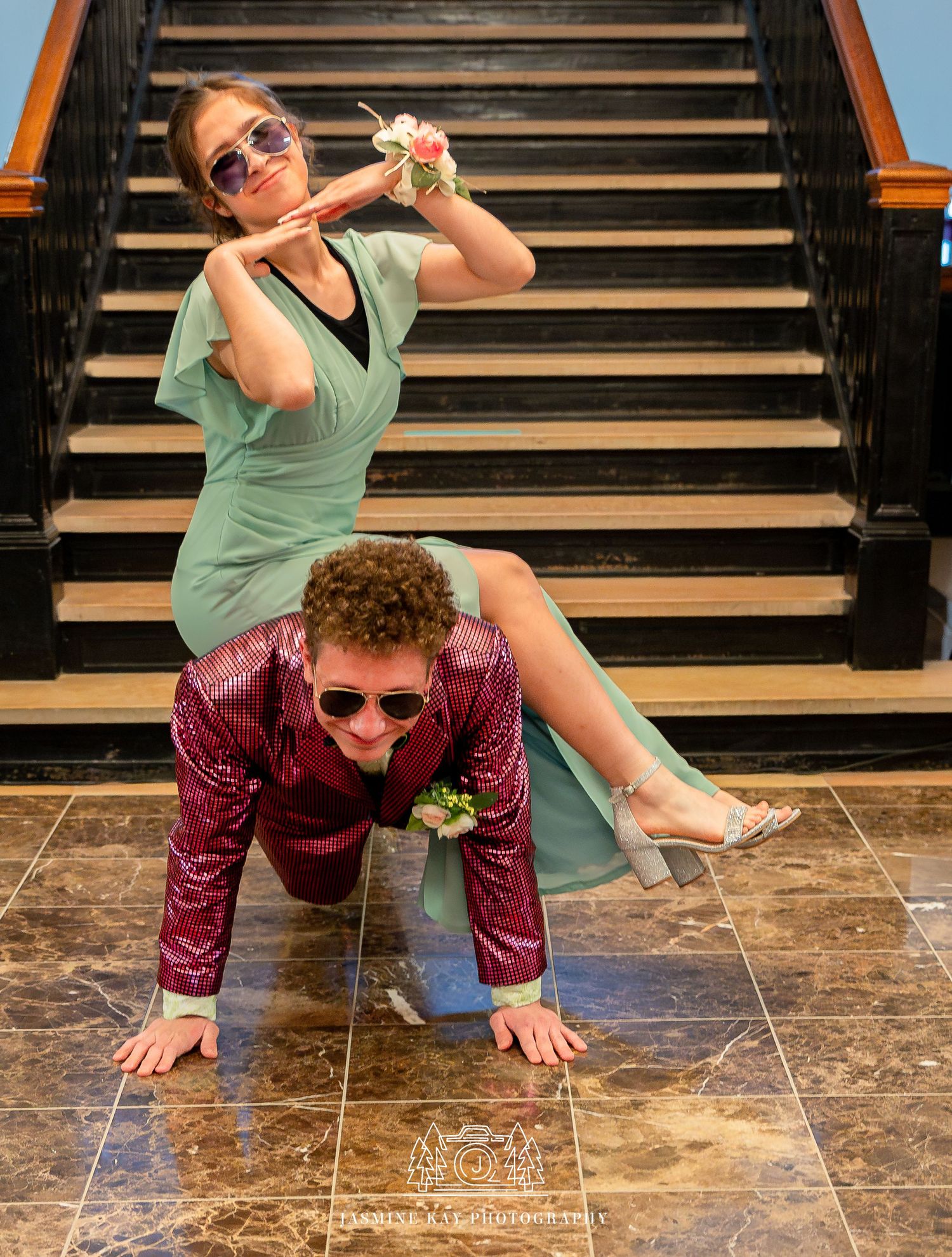 Person in mint green shirt and burgundy pants performs a dramatic falling sequence on wooden stairs.
