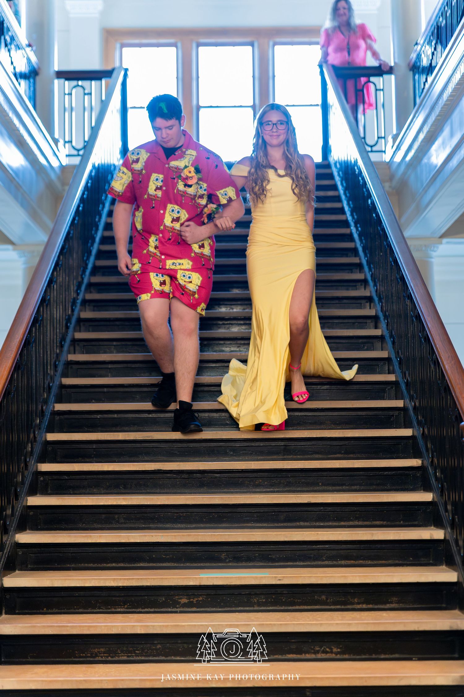 A sequence of photos showing two people in colorful dresses descending a grand staircase in a playful manner.