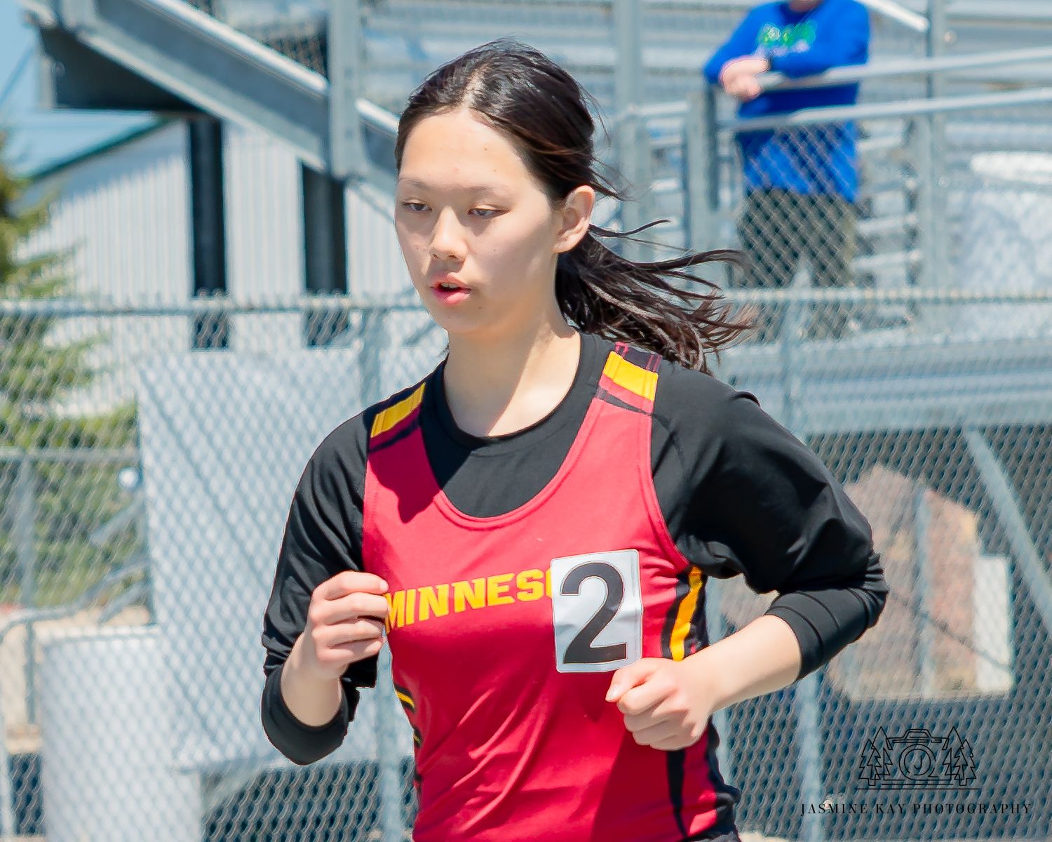 Track athlete demonstrates stretching exercises on an outdoor athletic field.