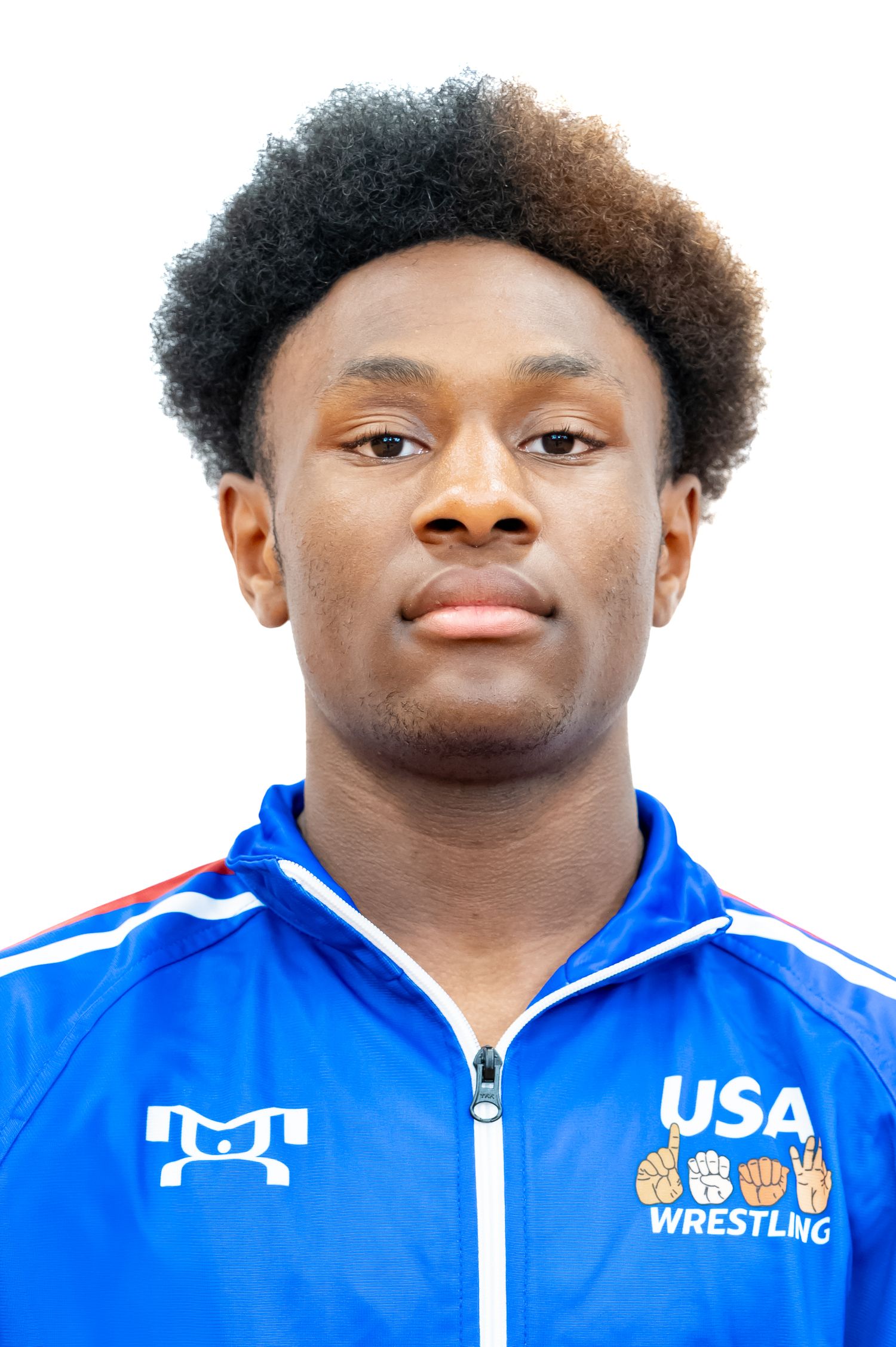 Close-up portrait of an athlete in a blue USA Wrestling team jacket with curly hair.