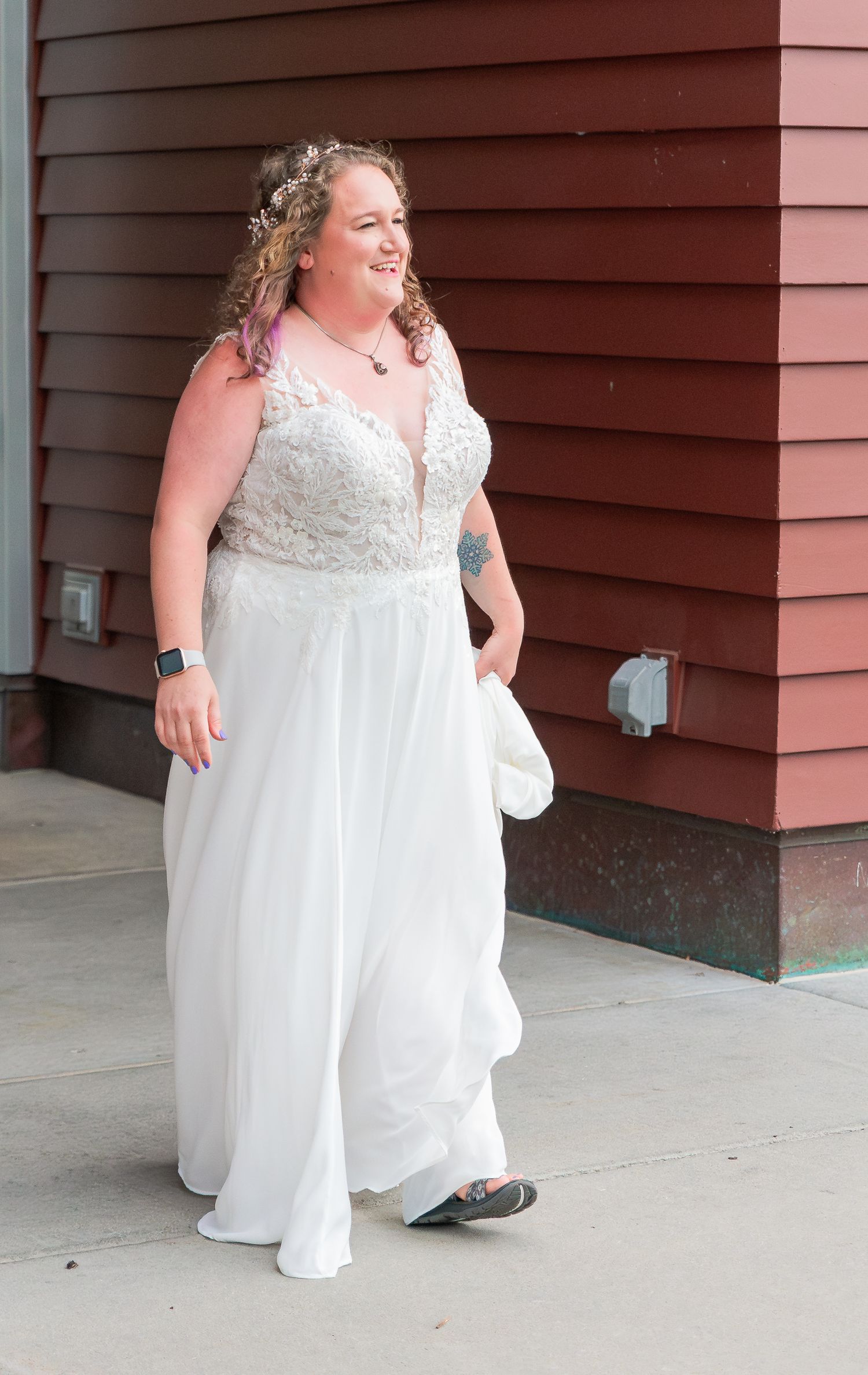A bride in a flowing white wedding dress poses playfully in a sequence of candid shots against a rustic red wall.