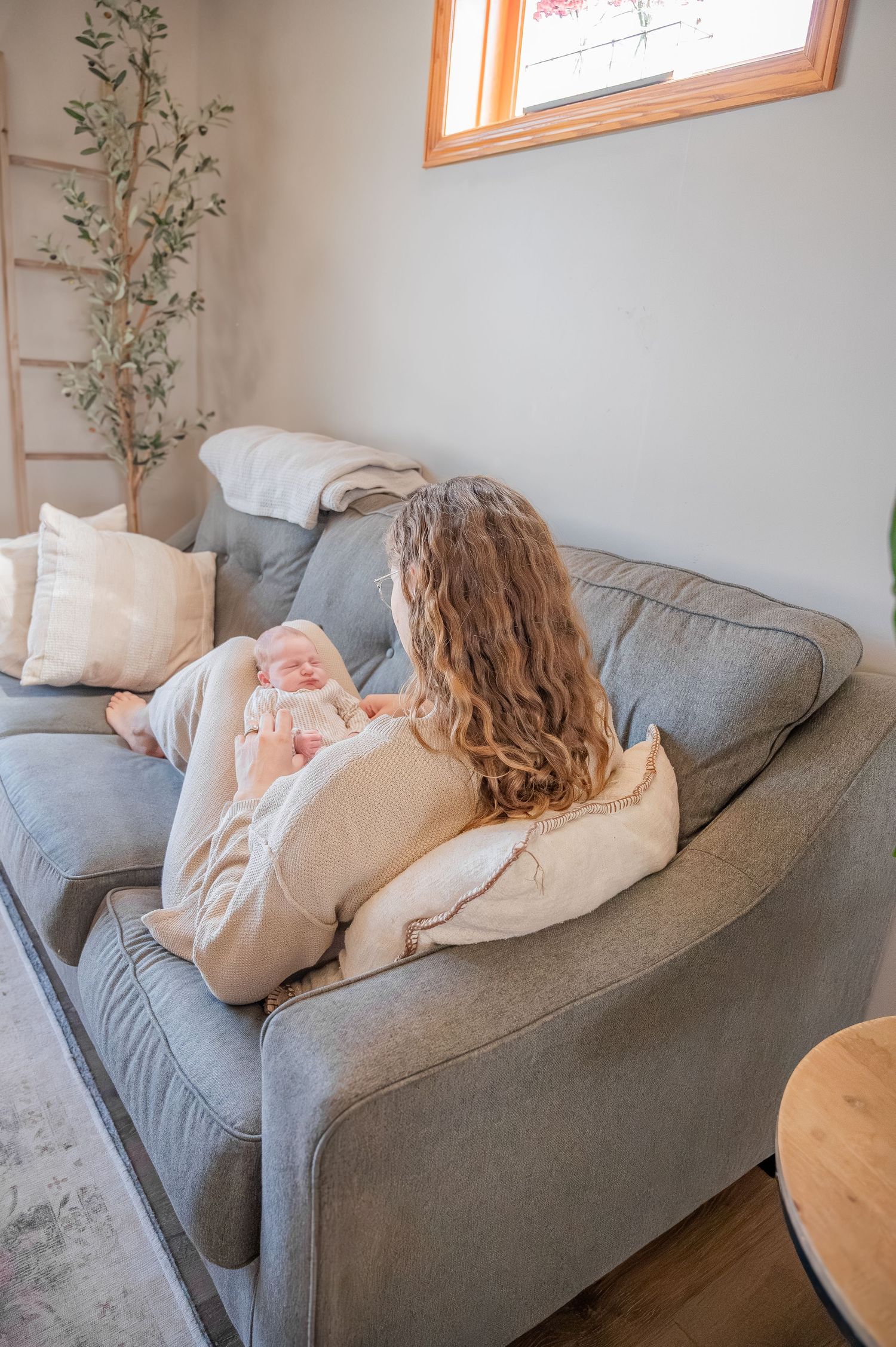 A series of three photos showing someone resting on a gray couch with decorative throw pillows and plants in the background.