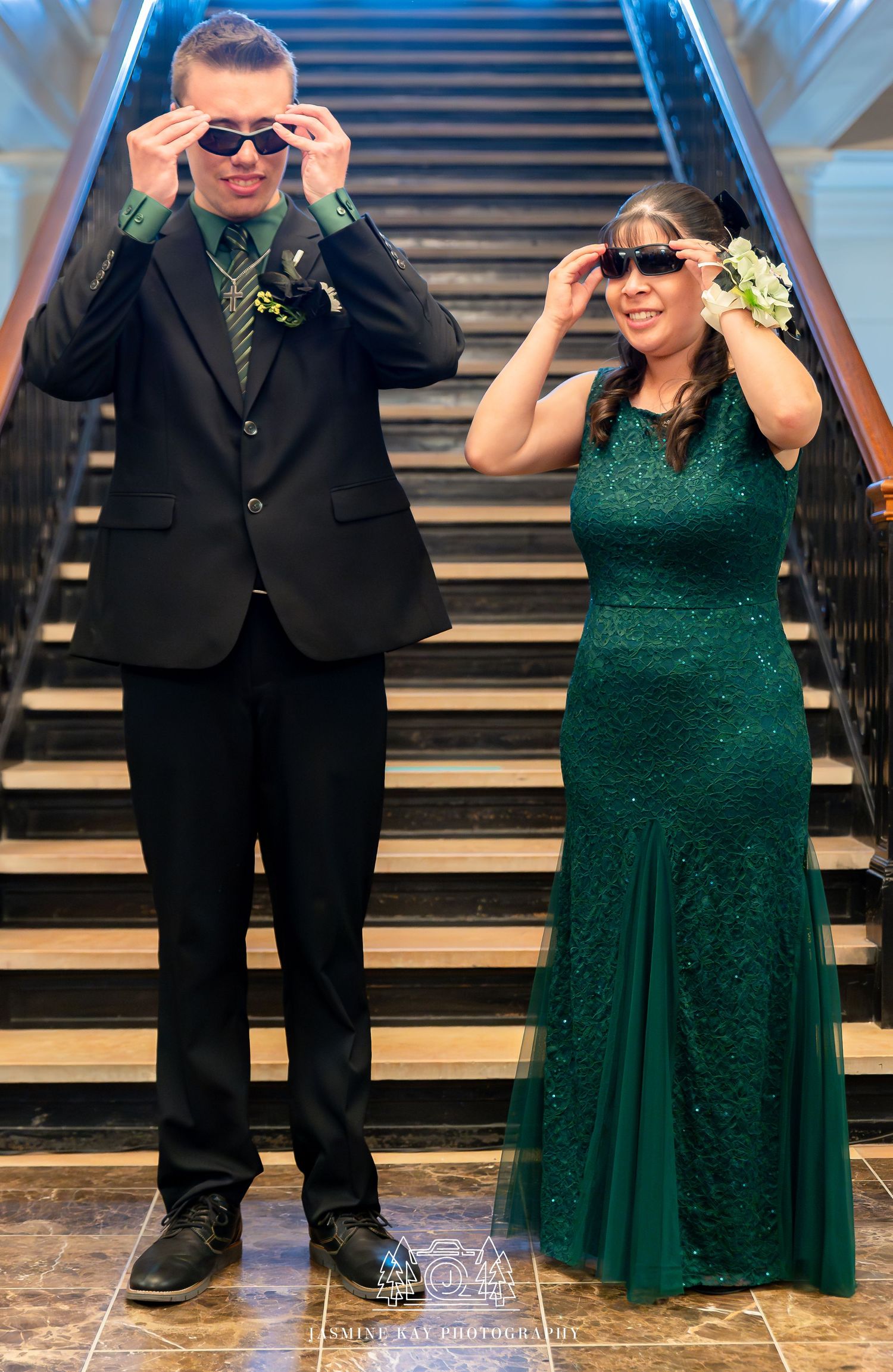 A couple in formal attire poses playfully with sunglasses on a grand staircase in a series of four photos.
