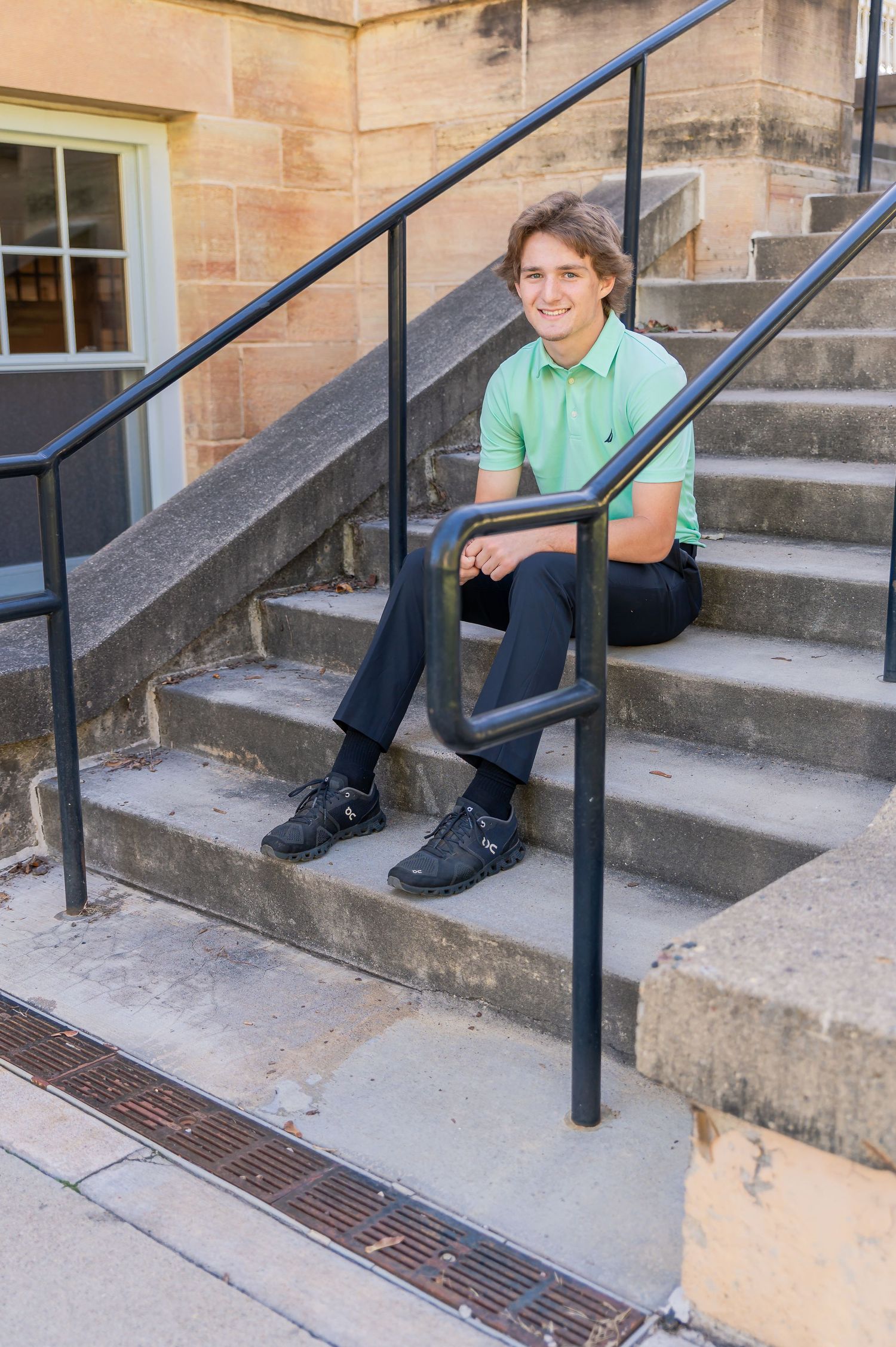 A sequence of five photos showing someone sitting on concrete steps next to a metal railing outside a building.