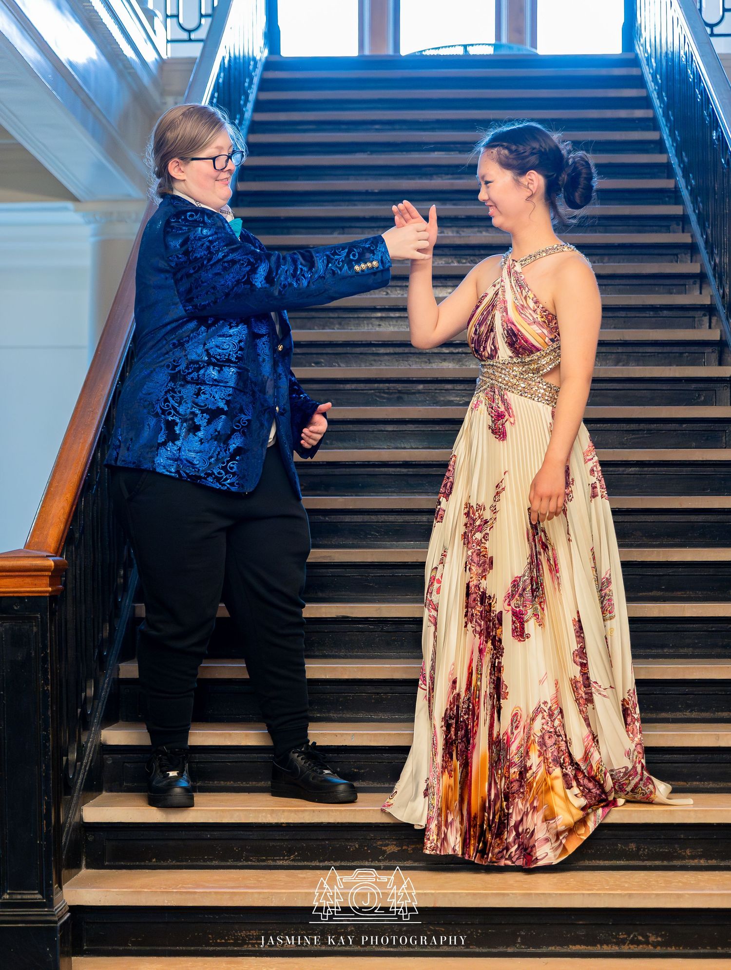 A couple shares a romantic moment on wooden stairs during a proposal photoshoot.