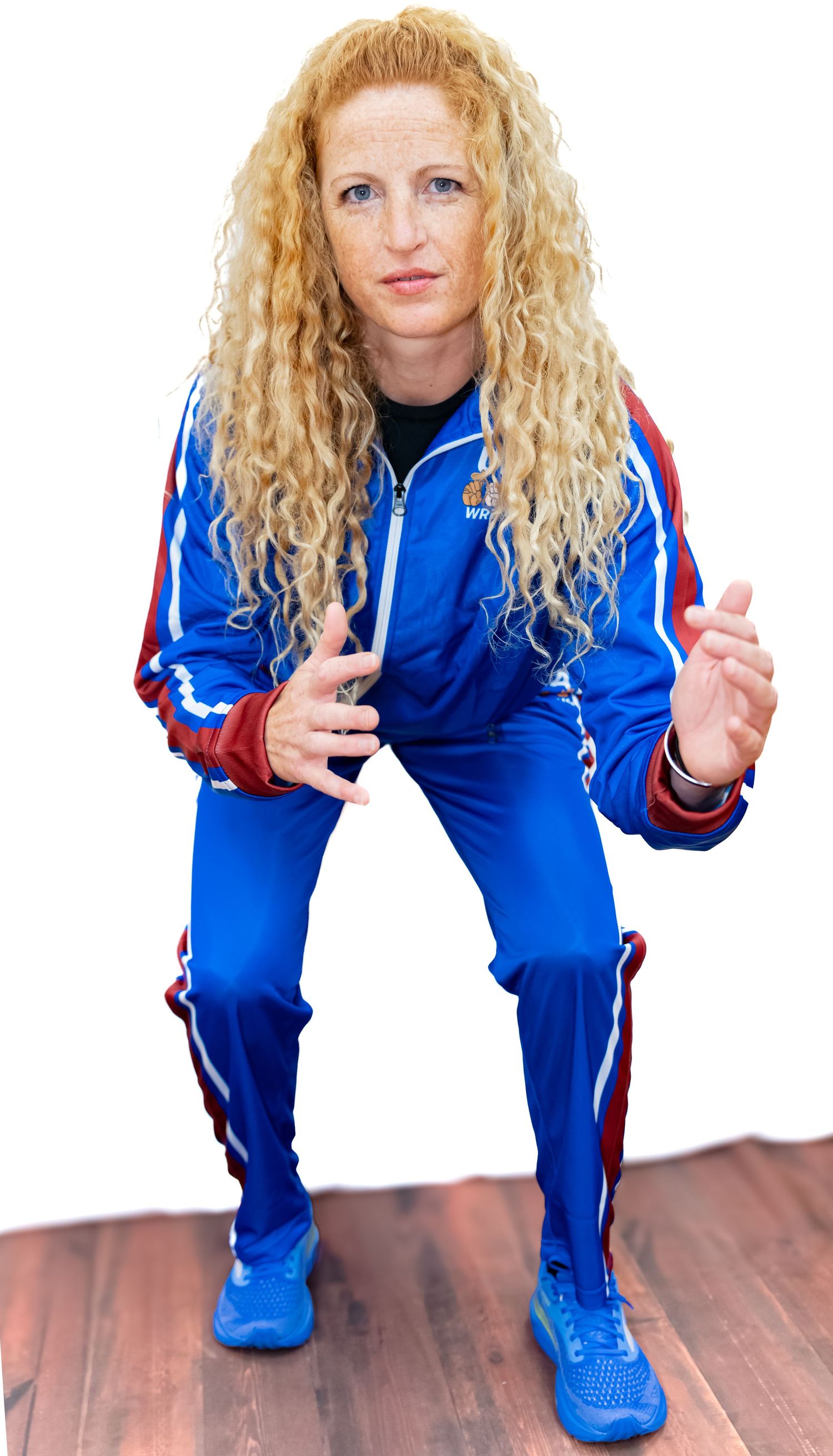 Person with curly blonde hair performing athletic stance progression in blue tracksuit.
