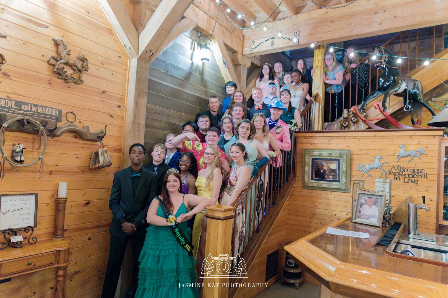 Wedding party gathers in rustic wood-paneled venue with elegant decor and natural lighting.