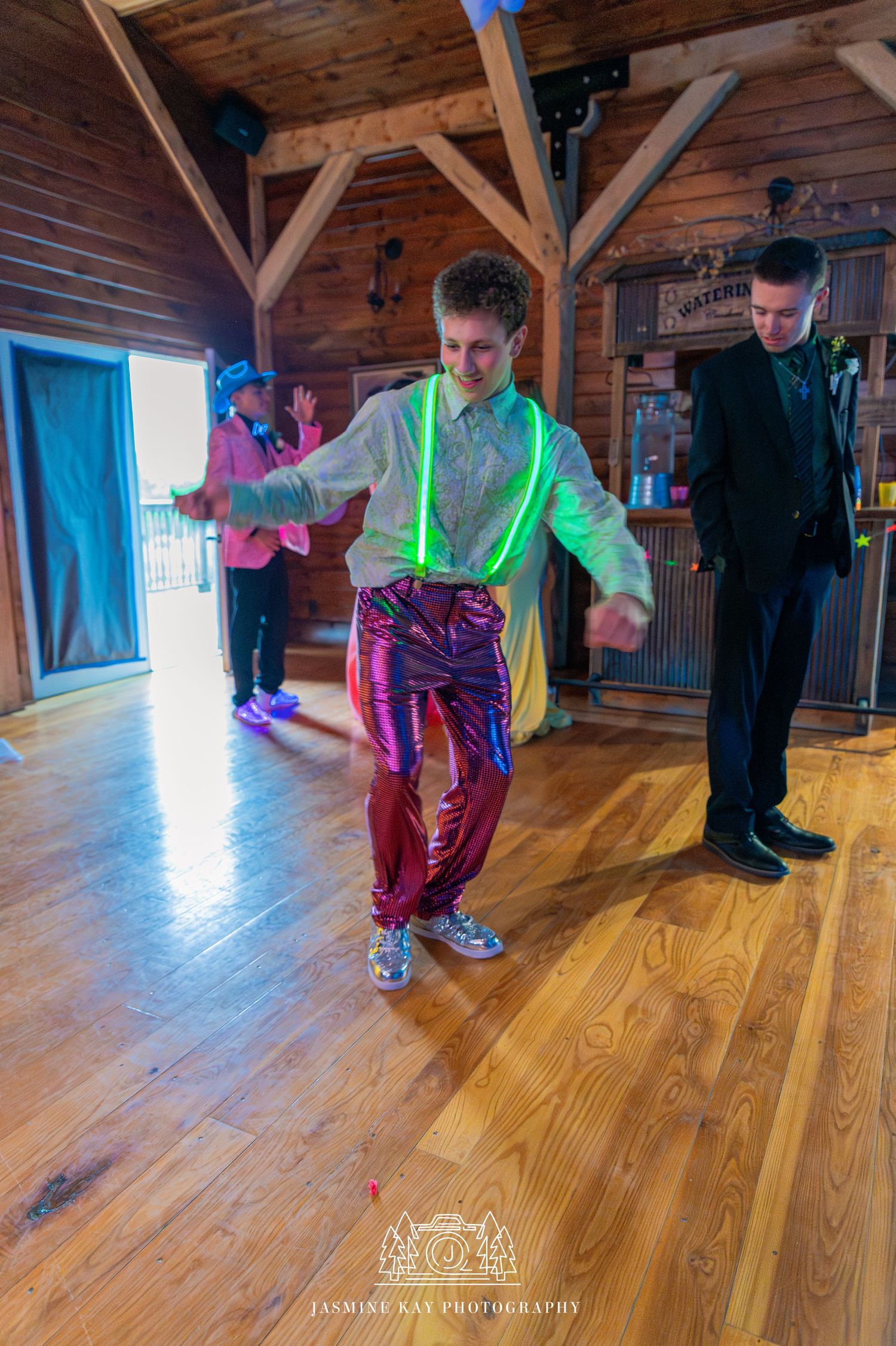 Dancers practicing breakdance moves on wooden floor in rustic studio space with natural lighting through windows.