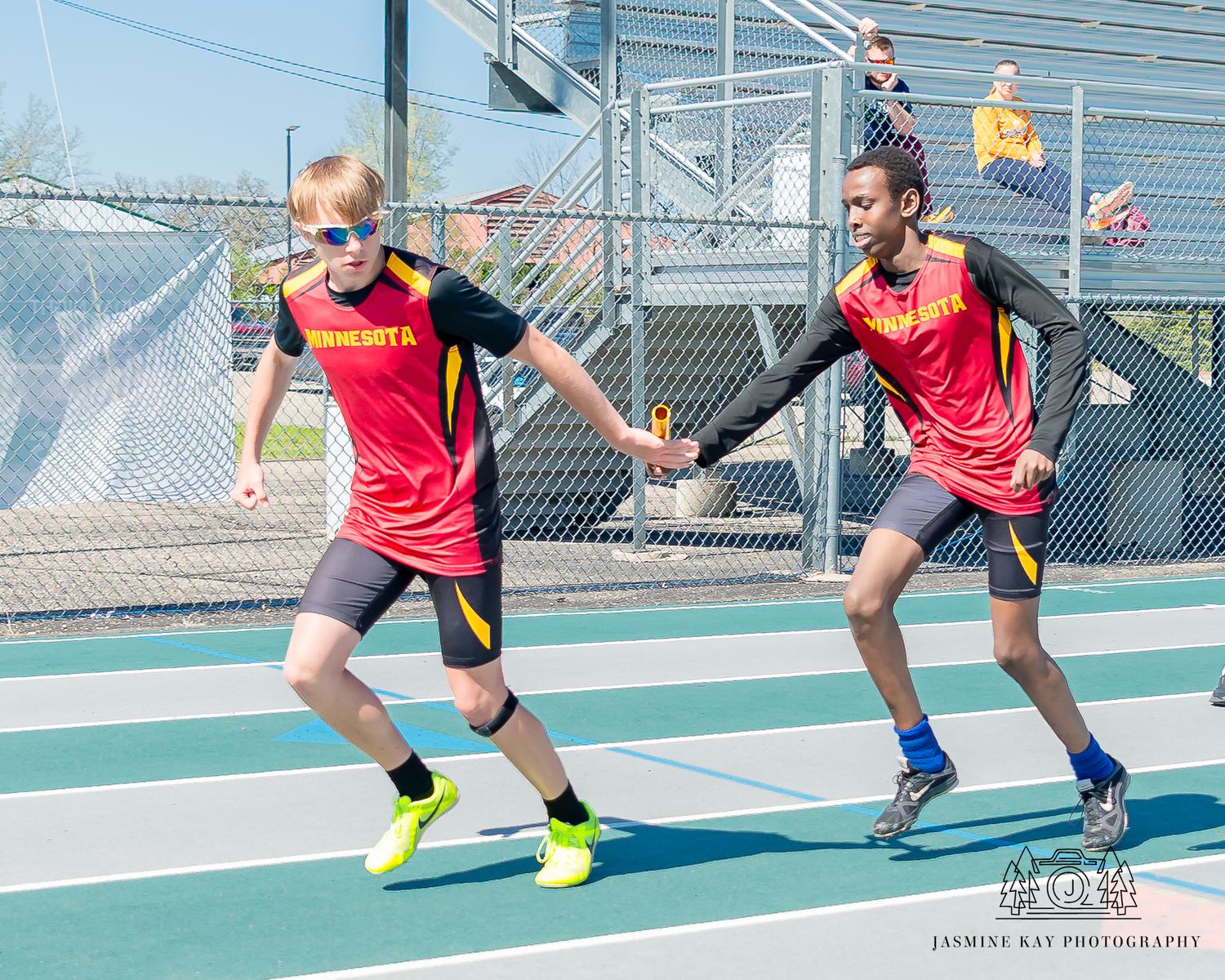 Athletes demonstrating proper form and technique during track and field drills on a green court surface.