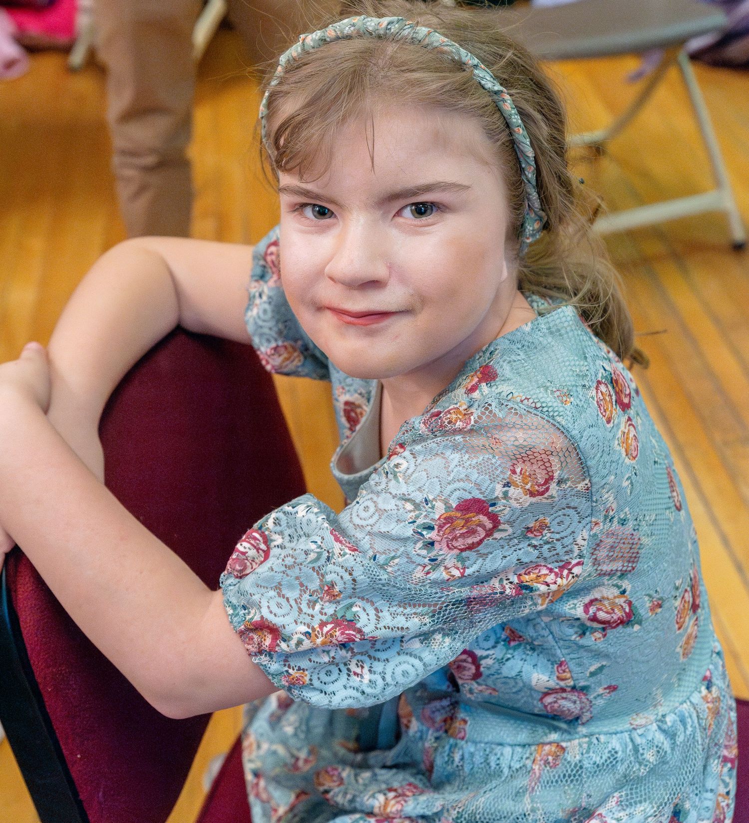 A performer in a light blue costume with floral details during a stage production.