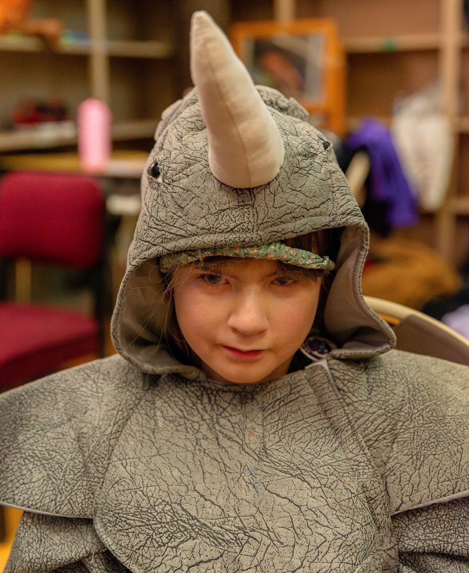 Person wearing a grey hooded costume during a theatrical performance.