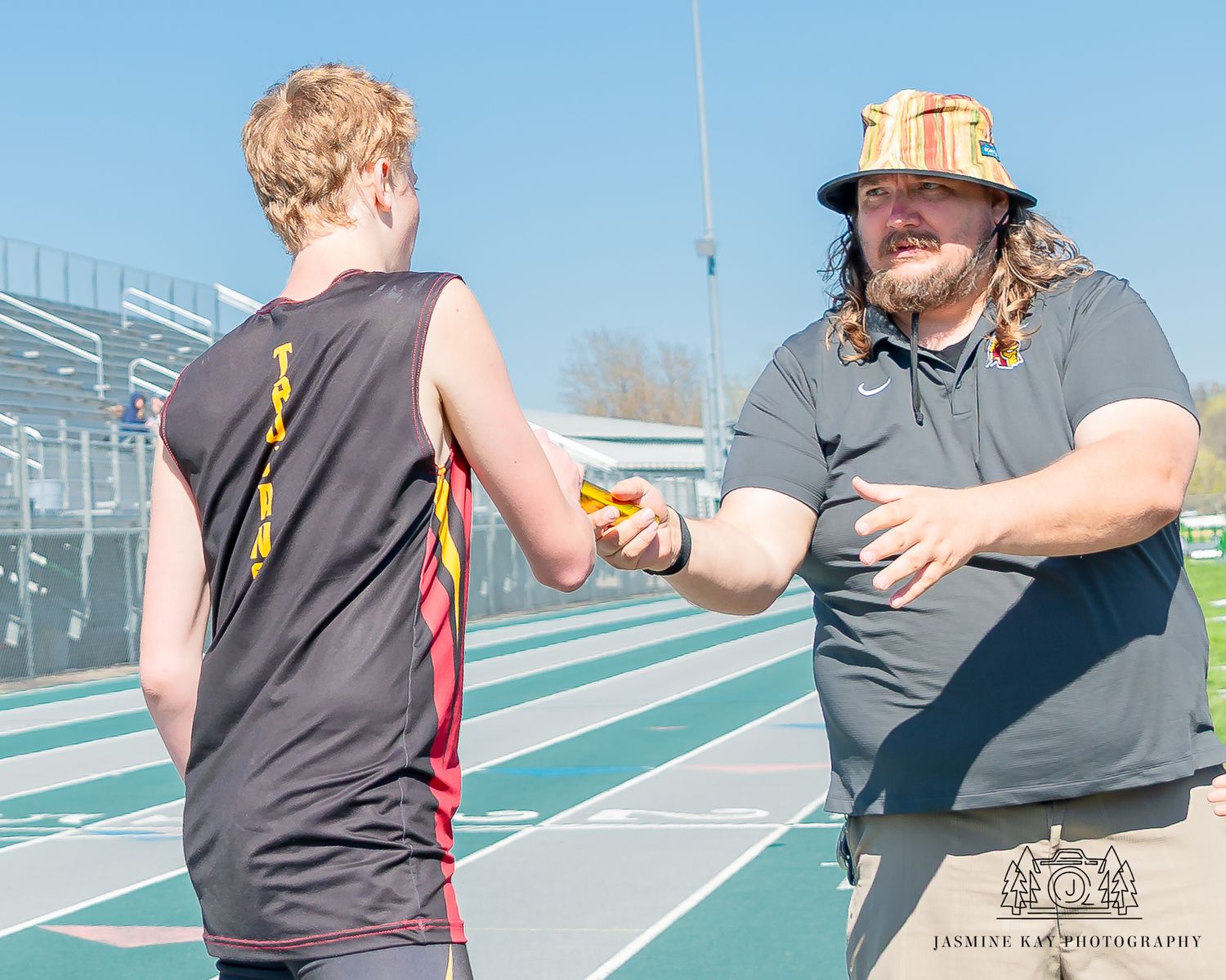 Athletes engaging in partner training exercises on an outdoor sports court during practice.