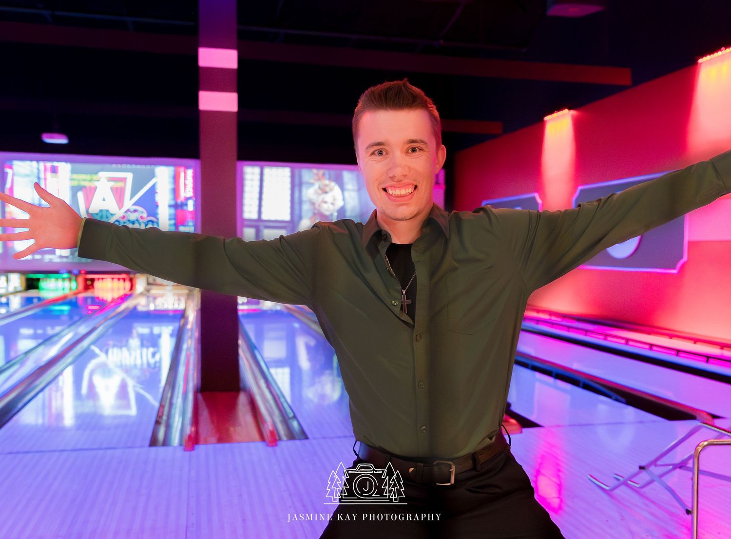 A colorful bowling alley illuminated with vibrant pink and blue neon lights showing multiple lanes and pins.
