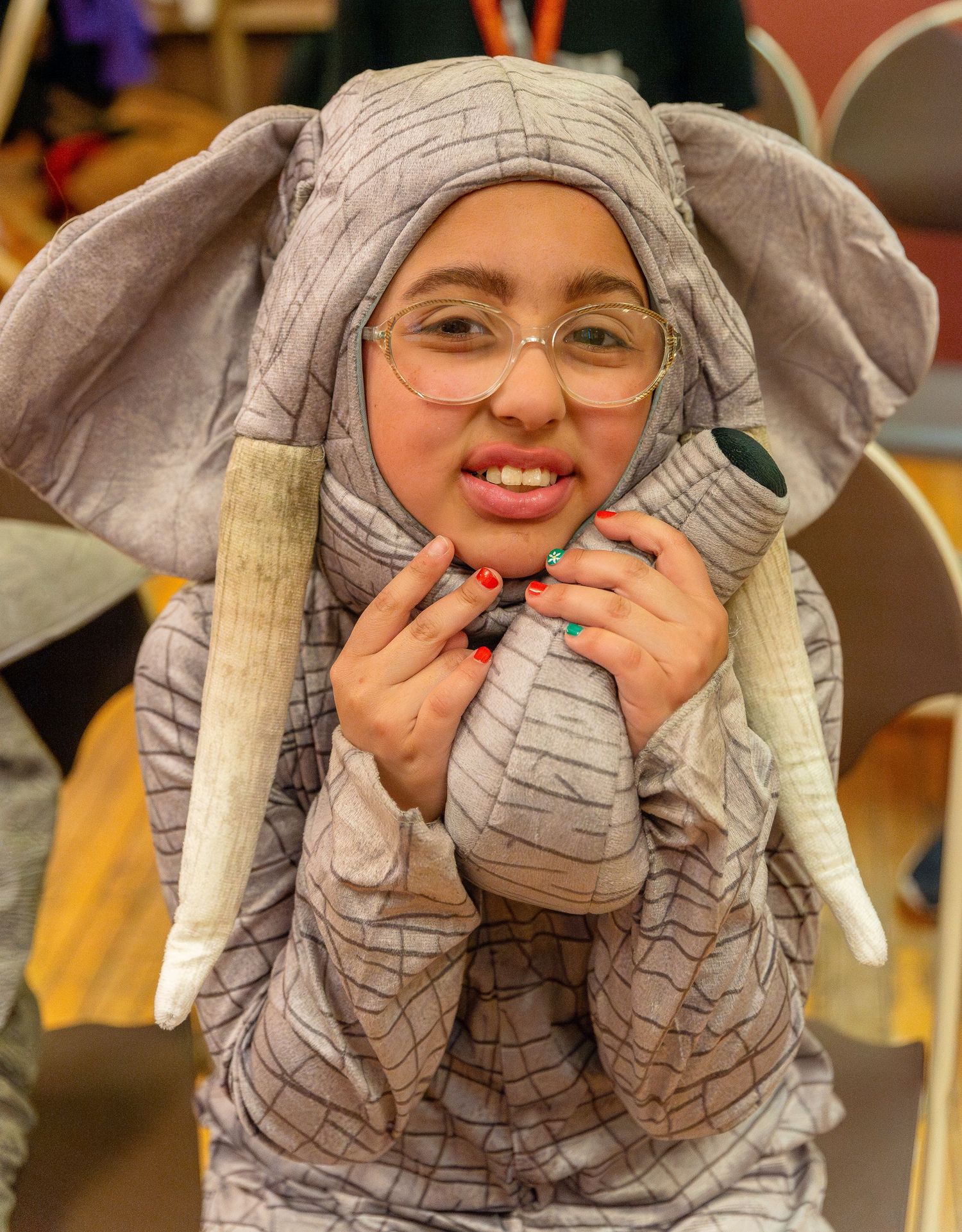 Performer in an elephant costume makes playful expressions during a theatrical show.