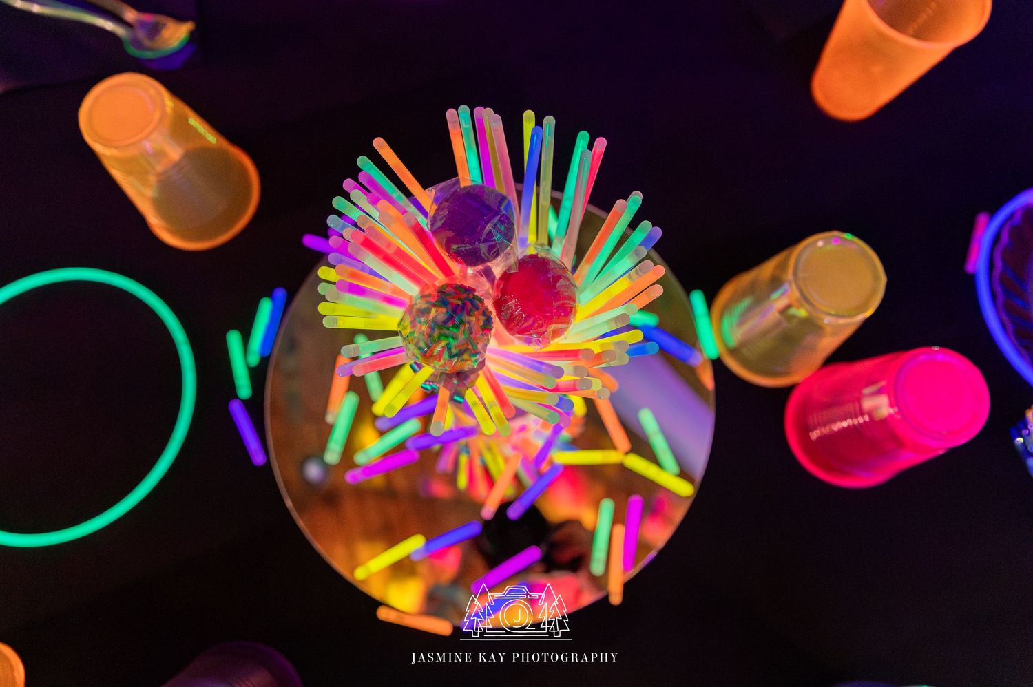 Colorful glowing light painting photography creates abstract neon patterns against a dark background.