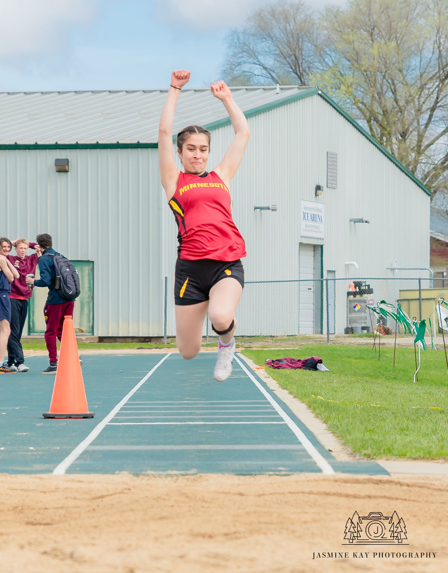 A sequence of photos showing an athlete performing a long jump at a track and field event.