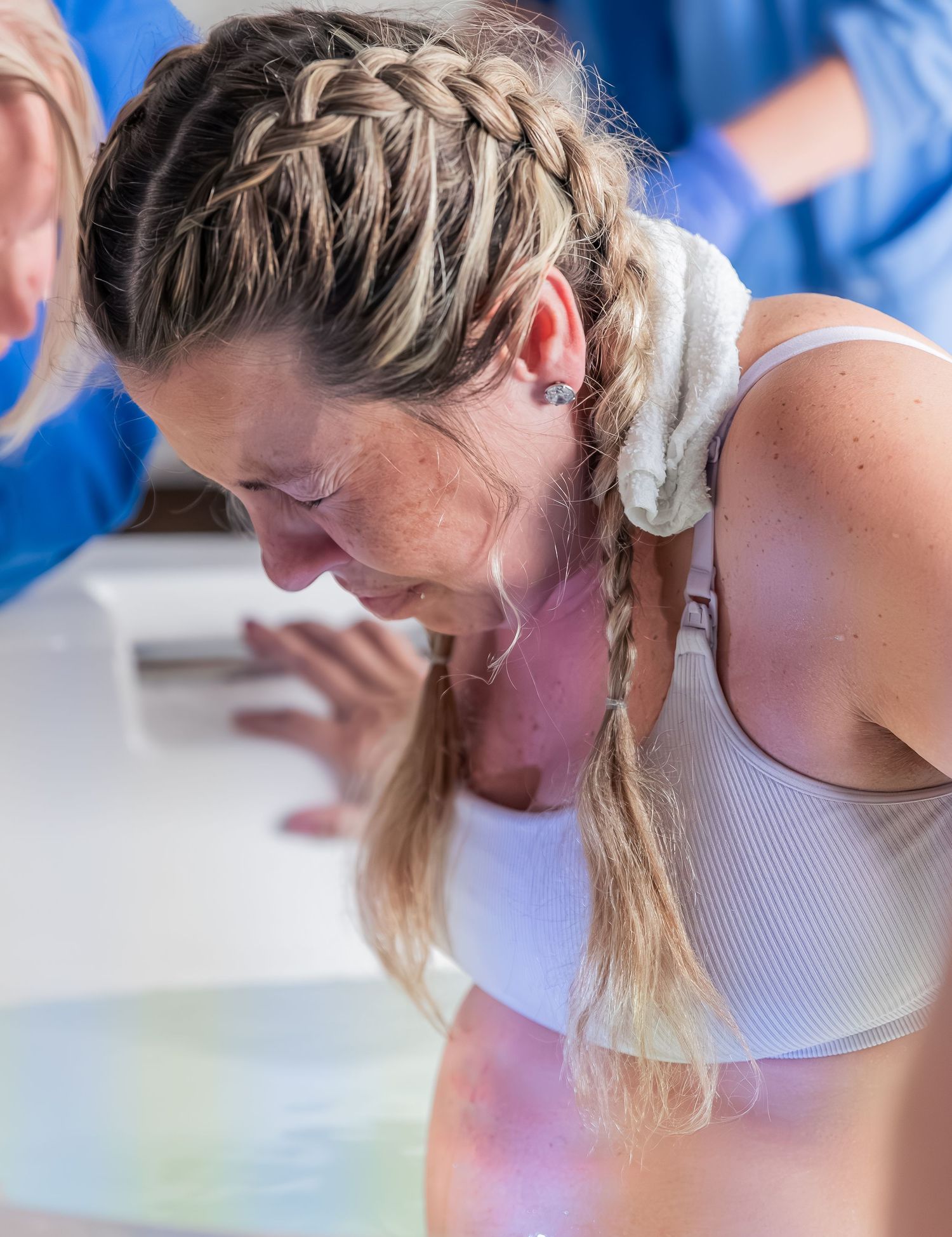 Person with blonde hair in a white tank top leans forward over a table in a series of progressive shots.