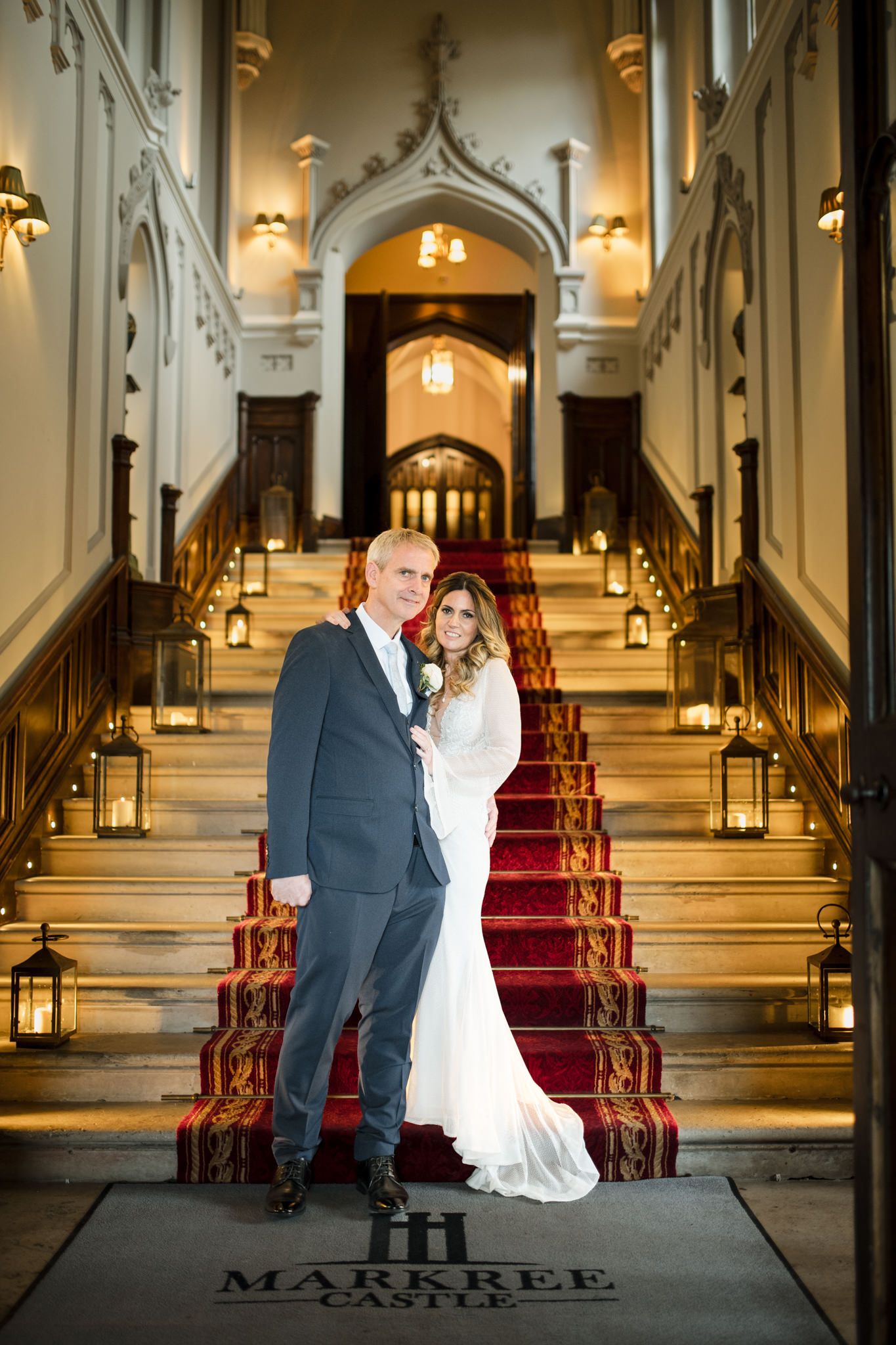 Romantic photo series at the Marrkee venue showing a couple posing on elegant stairs with red carpet and ornate details.