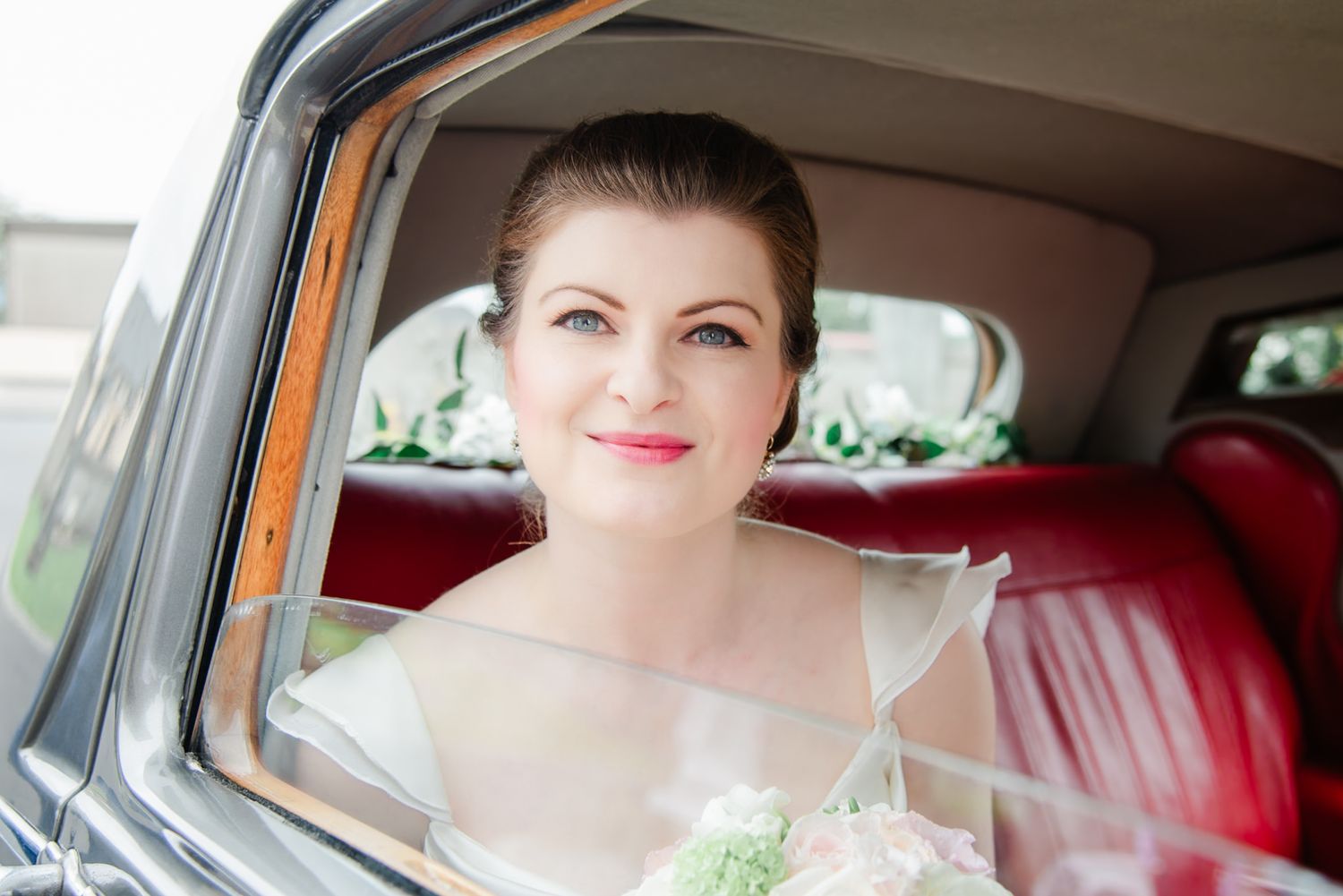 Classic portrait through vintage car window with red interior.