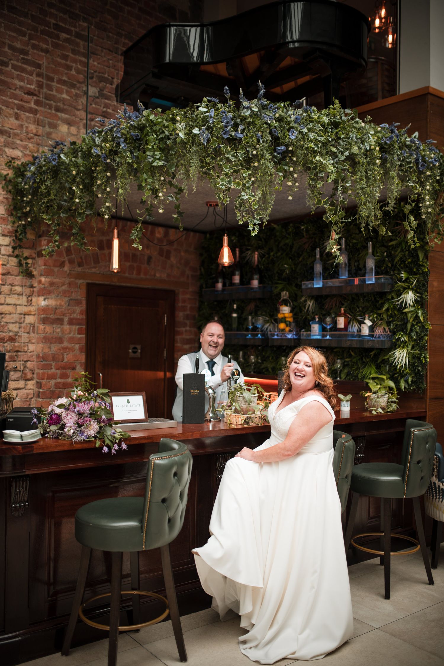Romantic restaurant interior with brick walls, hanging greenery, and elegant lighting featuring cozy dining ambiance.