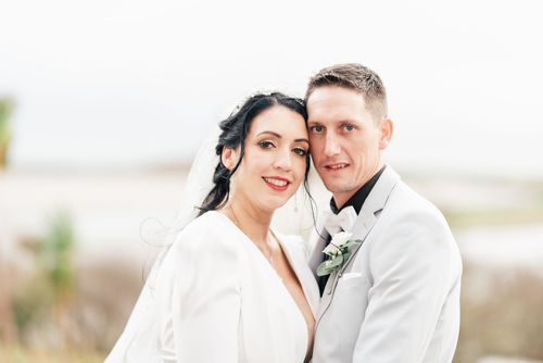 Wedding couple embraces and poses romantically in different angles against a bright outdoor backdrop.