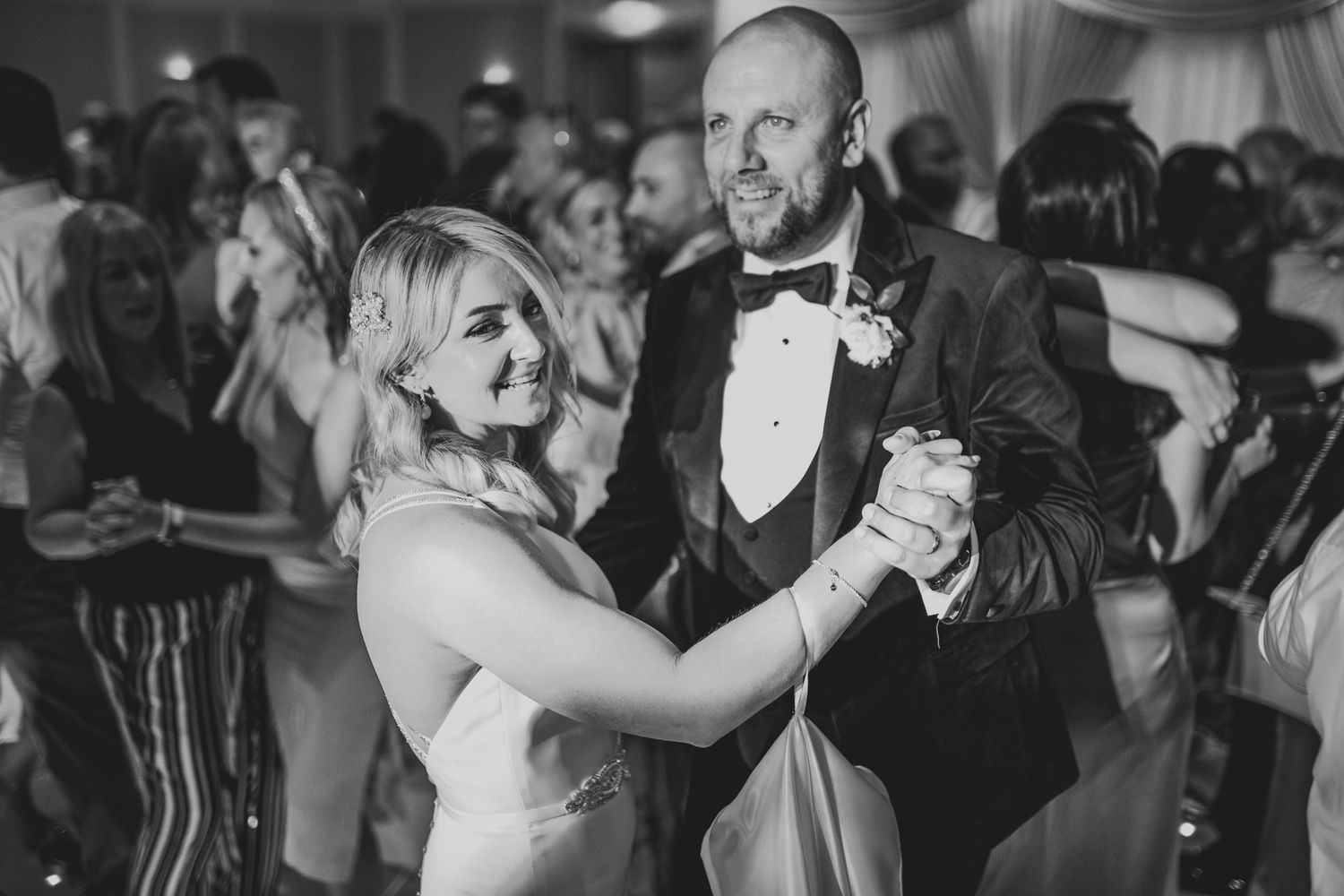Couples dancing at an elegant wedding reception in black and white.