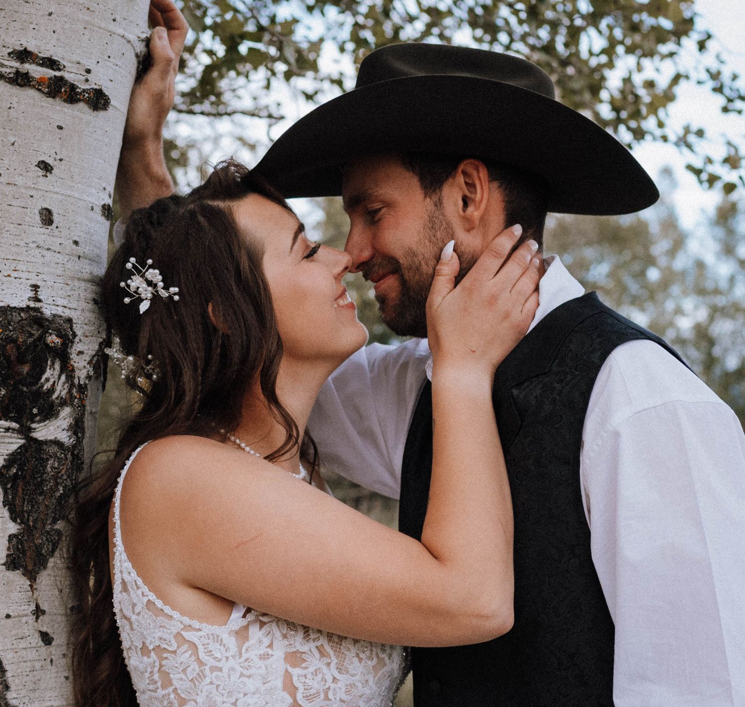 Romantic western-themed wedding portrait against birch tree backdrop.
